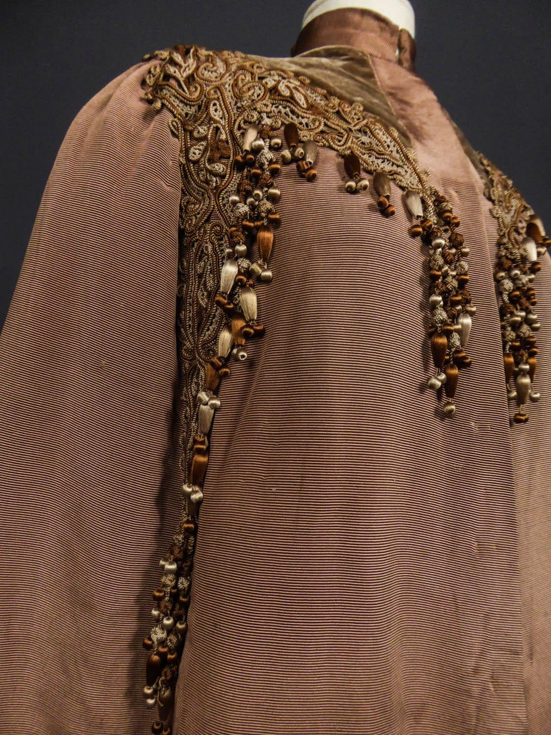 Circa 1890 - 1905
France

Large evening Cape in chestnut silk ottoman embroidered with trimmings dating from the late nineteenth century in the style of the french designer Emile Pingat. Cut to the shape of the shoulders, small raised collar, this
