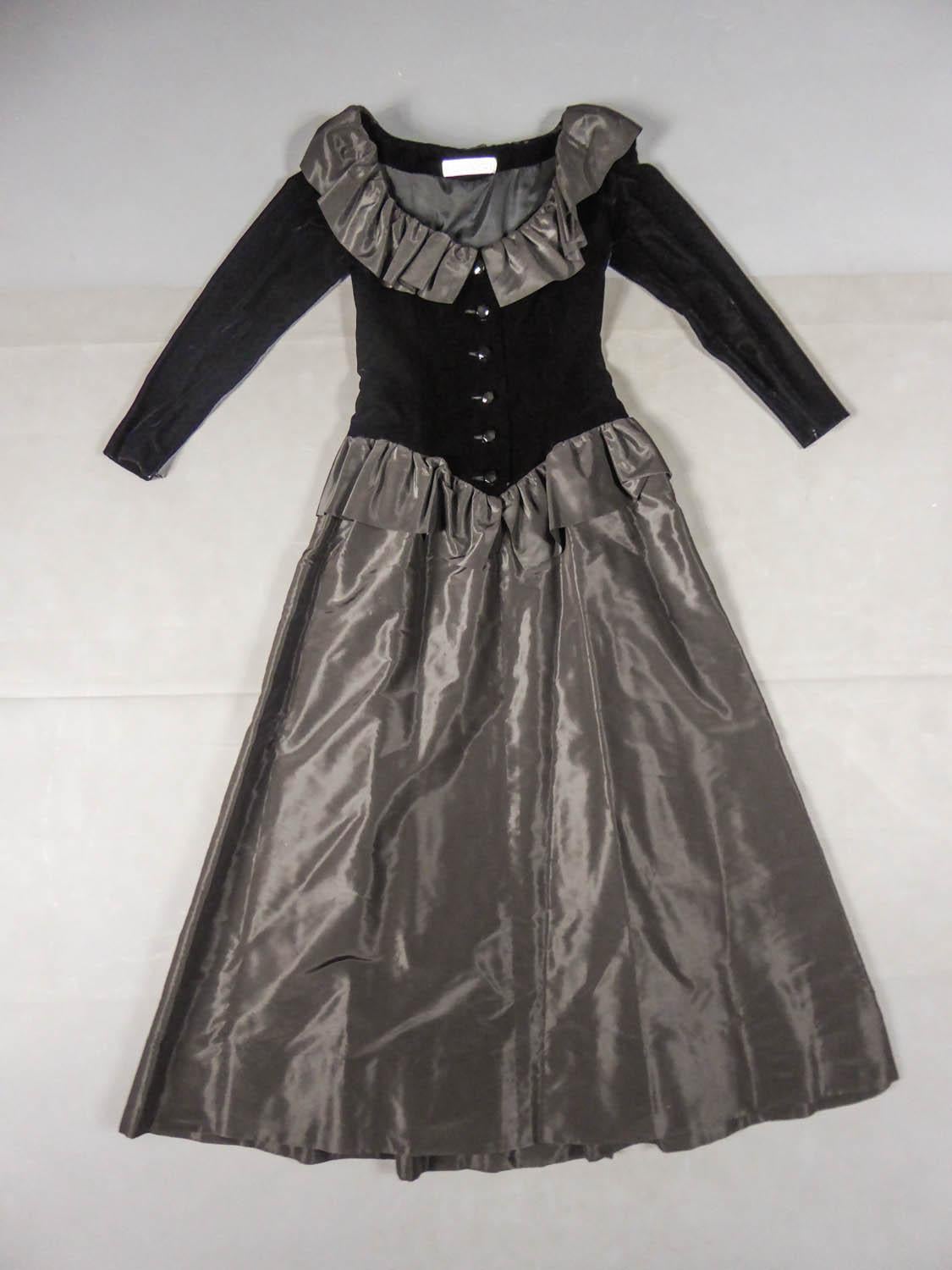 Circa 1980
France

Élégante robe du soir Givenchy Couture datant du début des années 1980. Jupe taille basse avec découpe en pointe sur le devant et volants en taffetas de soie noire. Bustier ajusté avec manches en velours noir et grand décolleté