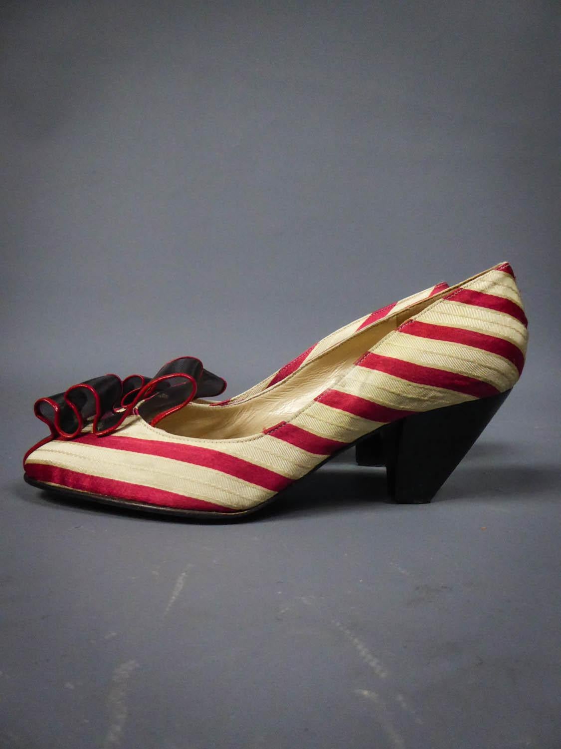 Circa 1960
France

Pretty pairs of heels shoes in striped silk in the shades of cream, red and gold with small black heels. Shaped silk with satin bands and cream faille. Rounded ends embellished with a strip of rigid plastic tulle surronded with