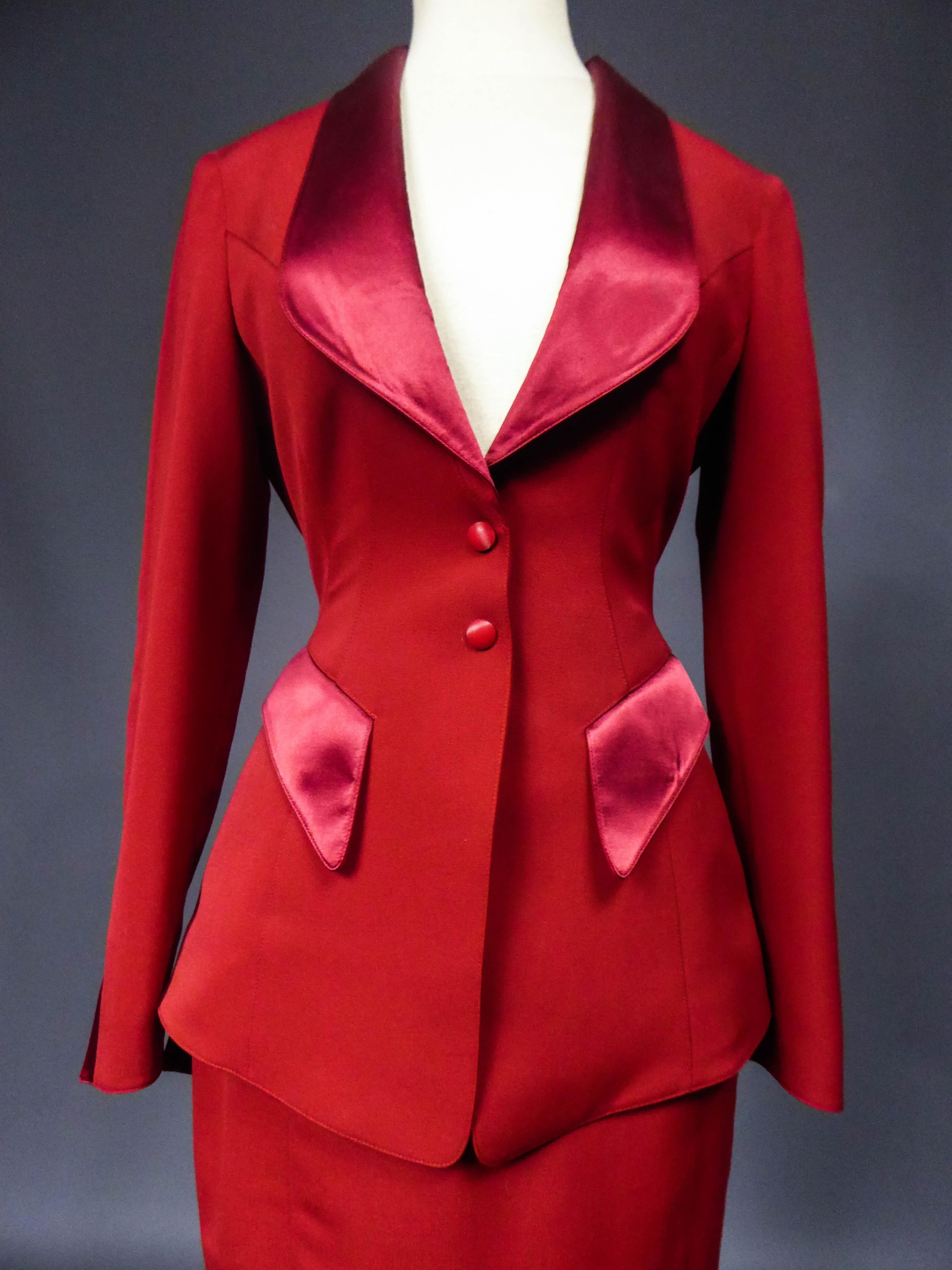 Circa 1990
France

Thierry Mugler jacket and skirt set in red brushed wool. Fitted jacket with large cleavage. Lapel collar, pockets and closure of the sleeves covered with red silk satin. Jacket in peak,  low-necked on the back and adorned with a