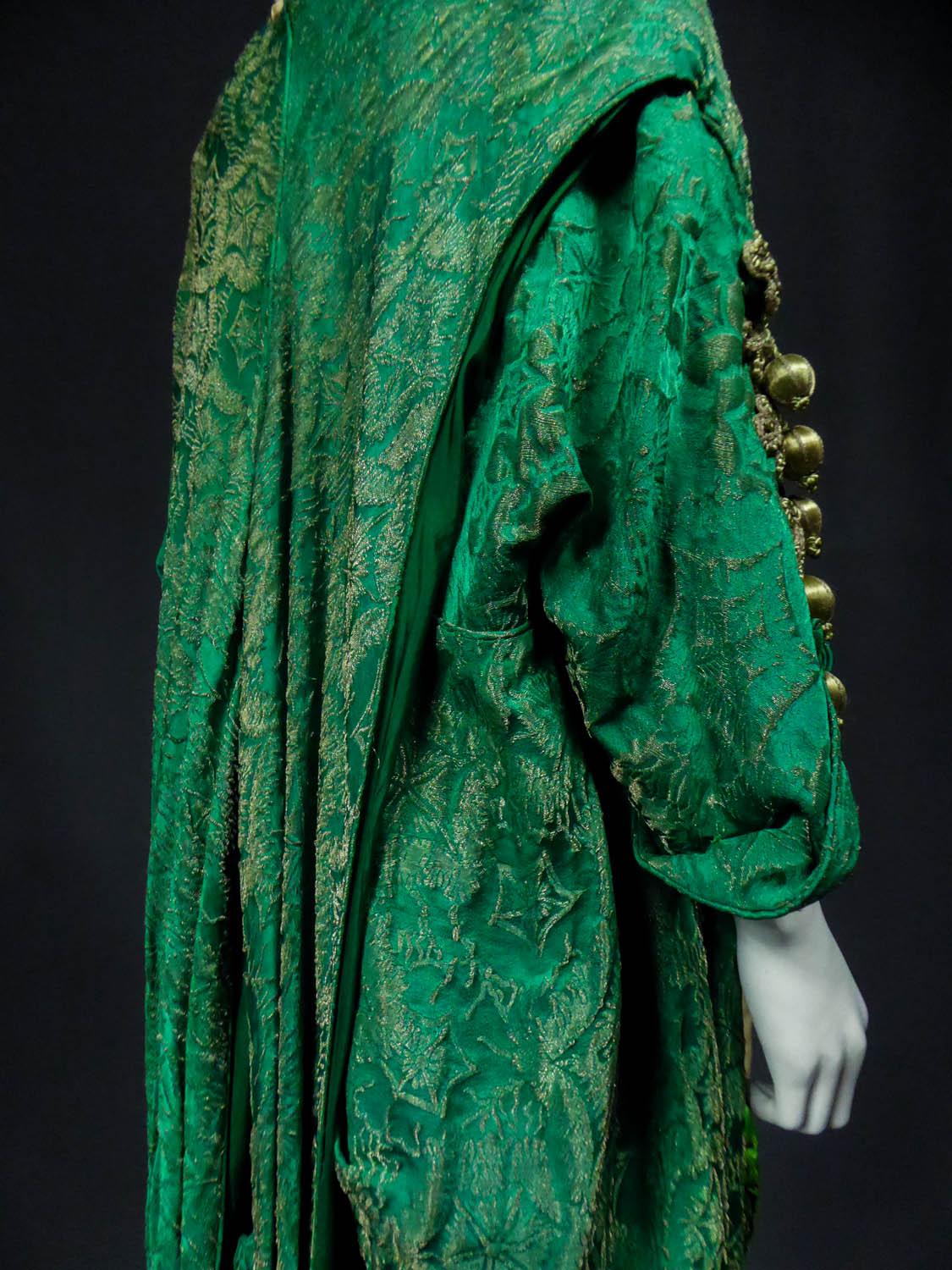 Circa 1915/1925
France

Long evening coat of Laborde & Cie designer house from Paris in gold and emerald green spangled brocade with stylized stars from the Belle Epoque. Orientalist cut as Paul Poiret did with volume of the bouillonné coat at the