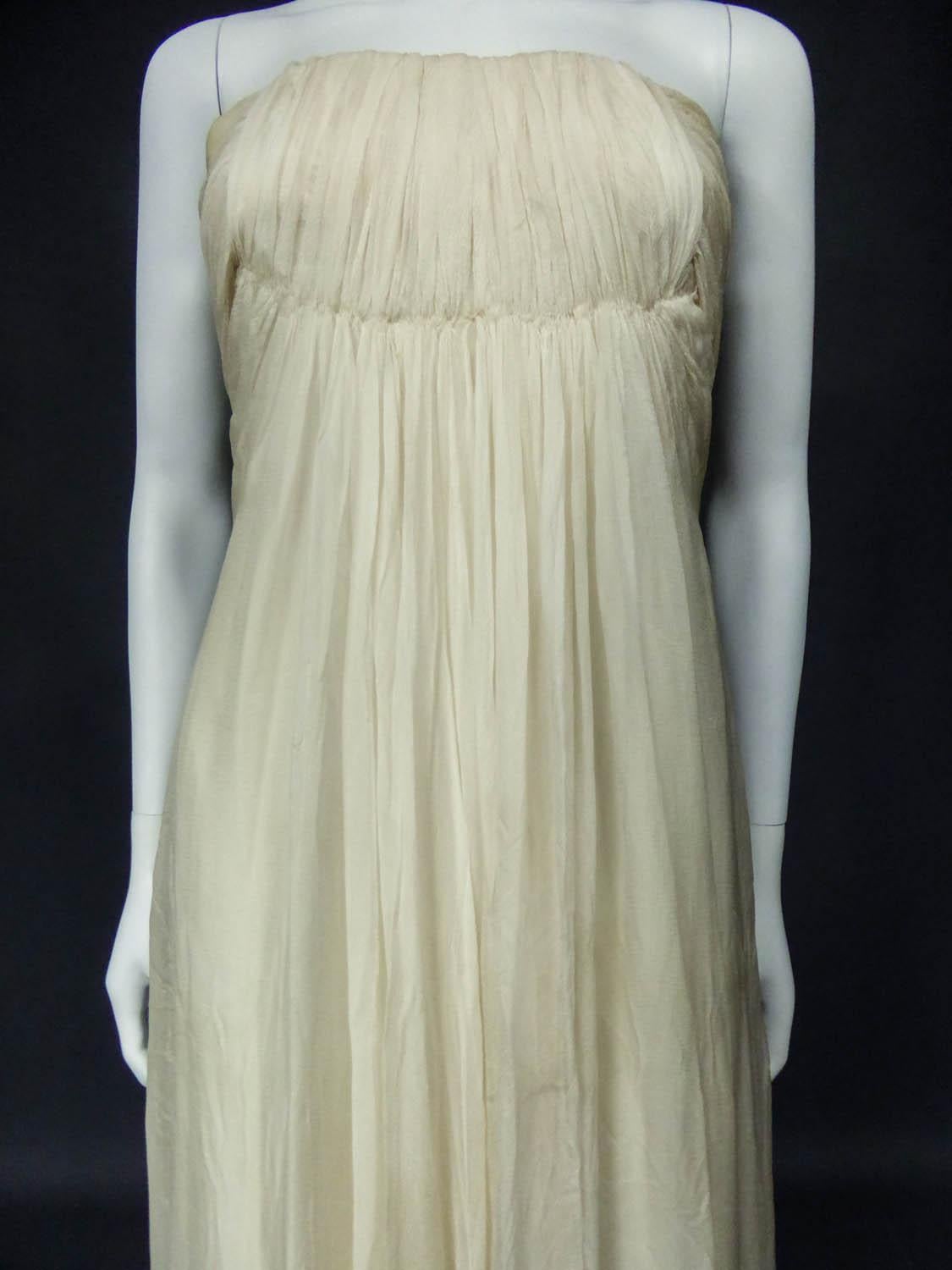 Circa 1970
France

Anonymous haute couture evening dress in chiffon and cream silk crepe from the 1970s. Probably from Jean Dessès or Carven designer house(?). An empire-inspired, high-waisted bustier dress with work of pleats at the chest.