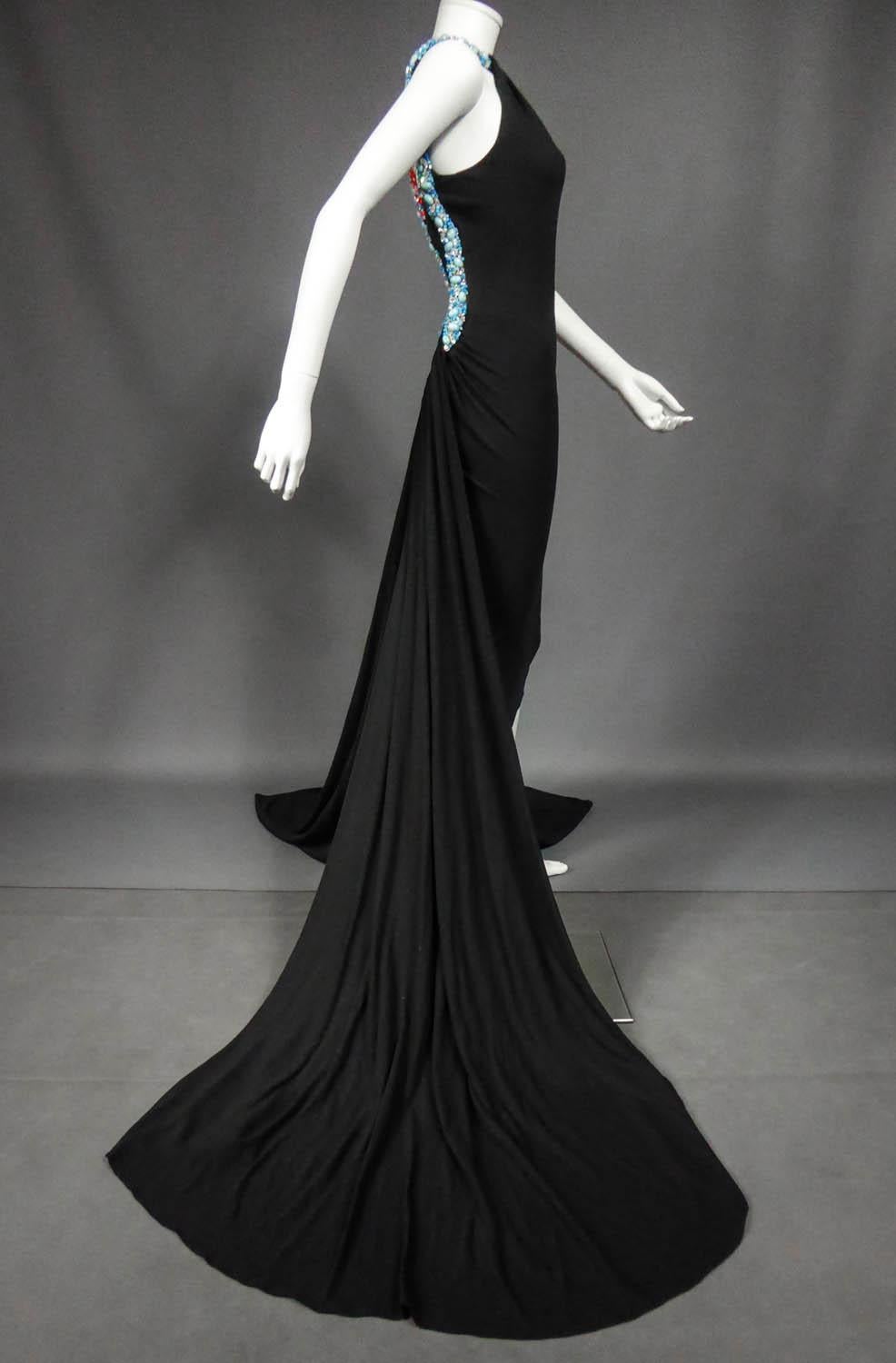 Spring / Summer 2001 Collection
France

Extravagant défilé dress from the Jean-Louis Scherrer designer house by Stéphane Rolland in black jersey from the Spring-Summer 2001 collection. Knee-length sheath dress with long trains projected towards the