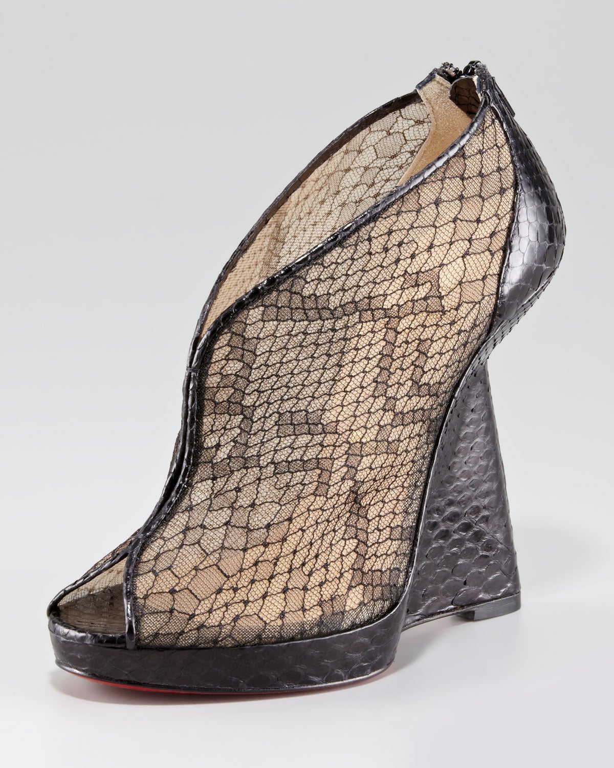 Christian Louboutin wedge bootie juxtaposes alluringly sheer mesh and exotic python. The shapely wedge heel creates a stiletto illusion when viewed from behind. 

Python-pattern lace complements python trim and base. 
Peep-toe. 
V'd vamp. 
Back