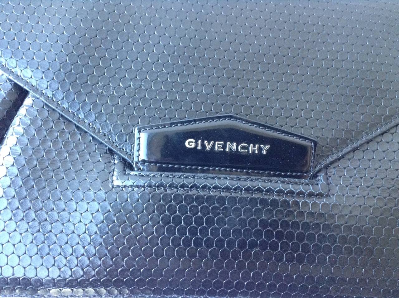 Givenchy Black leather Antigona envelope clutch.

Front flap detailed with metal logo letters; pleated body
Lined with cotton canvas; three-compartment interior
Slip-tab closure
8.25