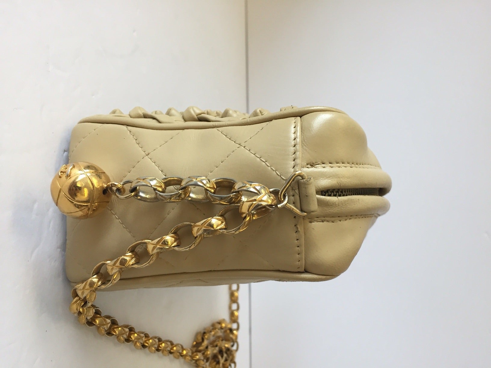 Chanel camera shaped cross body bag. Features knotted front pouch and gold CC logo charm. Single gold link strap.

Minimal signs of wear. Leather stands up quite well despite the age other than some slight cracking around the zipper. Clean