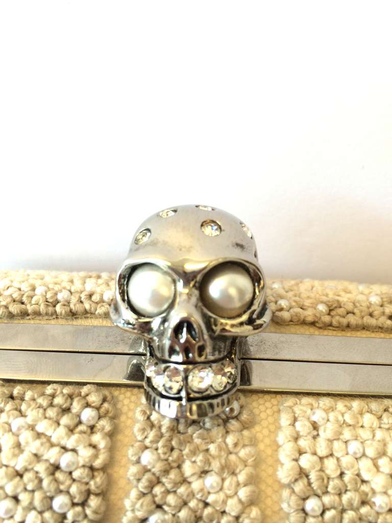 Specifics: Alexander Mcqueen antique-cream embroidered clutch. Features crystal skull head snap closure and pearl beading. Good Condition: lightly worn appearance. Clean interior. Code: 208024 000926.

Other
Made in Italy
Style: Clutch
Length: