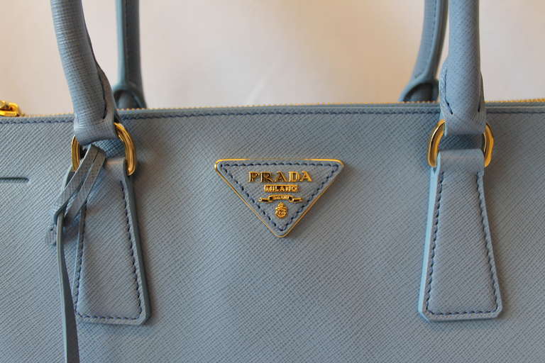 In Prada's most gorgeous and classic design, this Prada Saffiano in cobalt blue is a stunning addition to any collection. A sturdy and luxurious design, this bag is the ever popular medium-size and with the strap as a new addition from this season.