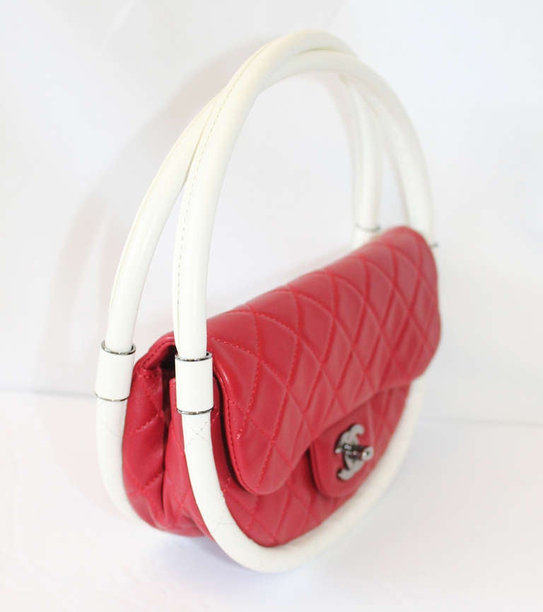 This stunning Chanel piece comes straight from the Runway and into your closet. In a gorgeous fire-engine or lipstick red colour, the Chanel bag is contrasted by two overlapping hoops to give the illusion of the hula hoop bag. 

The bag is in
