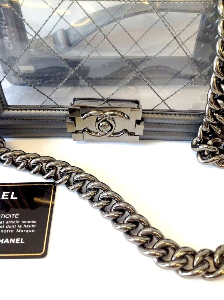 Current Season Chanel Le Boy Bag in the classic size. This gorgeous clear bag with calfskin leather trim and heavy brushed silver hardware. The serial number beginning with 18 denotes this bag as mid 2013 - current season. This bag has never been