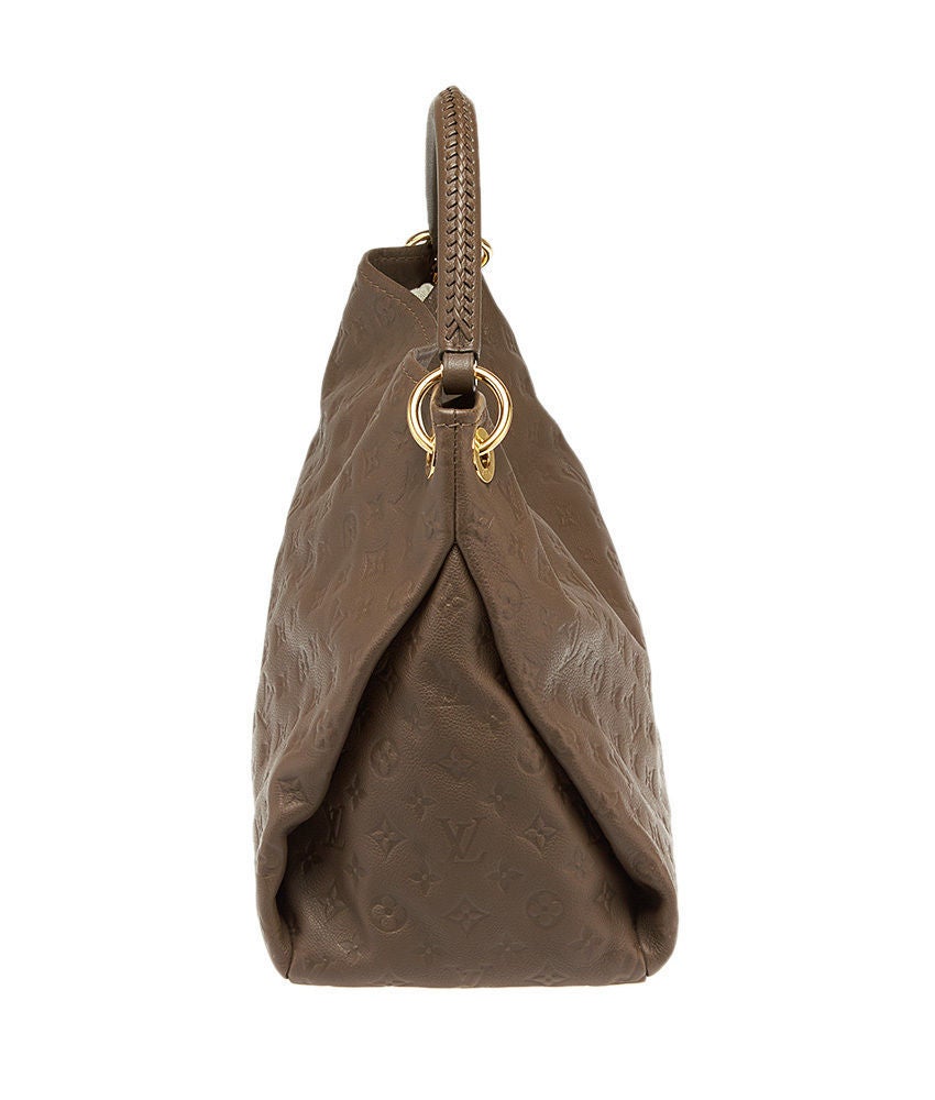 This is an authentic LOUIS VUITTON Monogram Empreinte Artsy MM in HAVANE . This stunning shoulder bag is crafted of a large quantity of Louis Vuitton monogram embossed leather in purple. The bag features a thick looping leather shoulder strap and