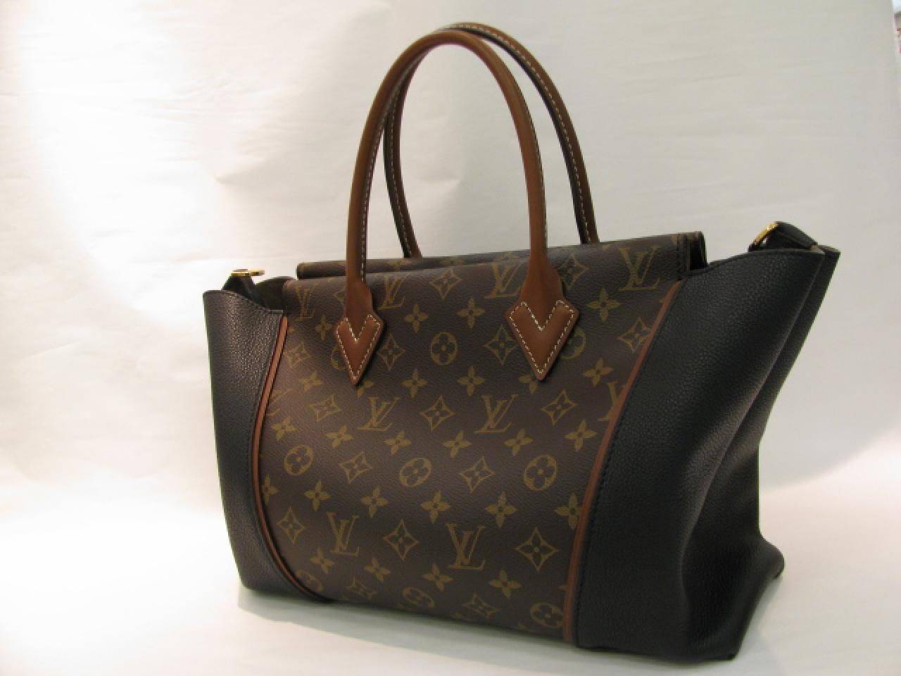 This is an authentic LOUIS VUITTON Monogram W PM in Black. This luxurious and elegant handbag is finely crafted of classic monogram toile canvas and supple black box calfskin leather. The leather piping trim matches the cafe brown rolled leather top