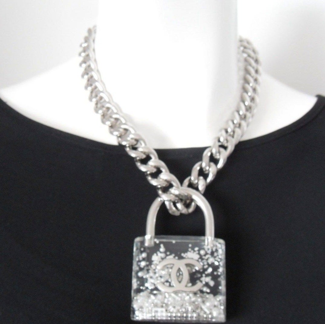 100% Authentic
Brand New with Tag, Never Worn
2014 CHANEL Transparent Plexiglass Padlock Adjustable Necklace
Lock has Small Sequins, White Faux Pearls, Silver CCs, Silver Balls / Tubes & Confetti Inside
CC Logo on Front
Small CC Charm Dangling
