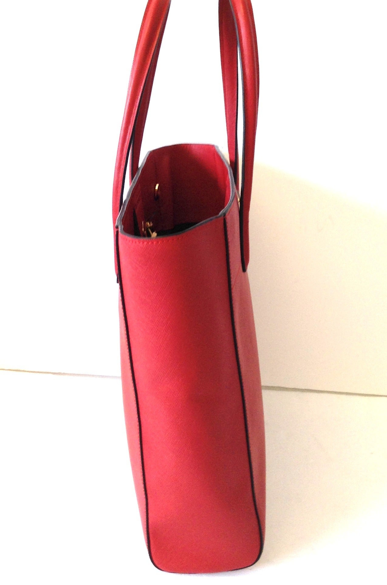 2013 PRADA Saffiano Tote in Red Lipstick 
WITH STRAP - DUST BAG - AUTHENTICATION 
IMMACULATE CONDITION - MINOR MARK 
Clean inside and out
Made in Italy 
HEIGHT 12 INCHES - WIDTH 18 INCHES - DEPTH 5 INCHES 
Hardware in Gold