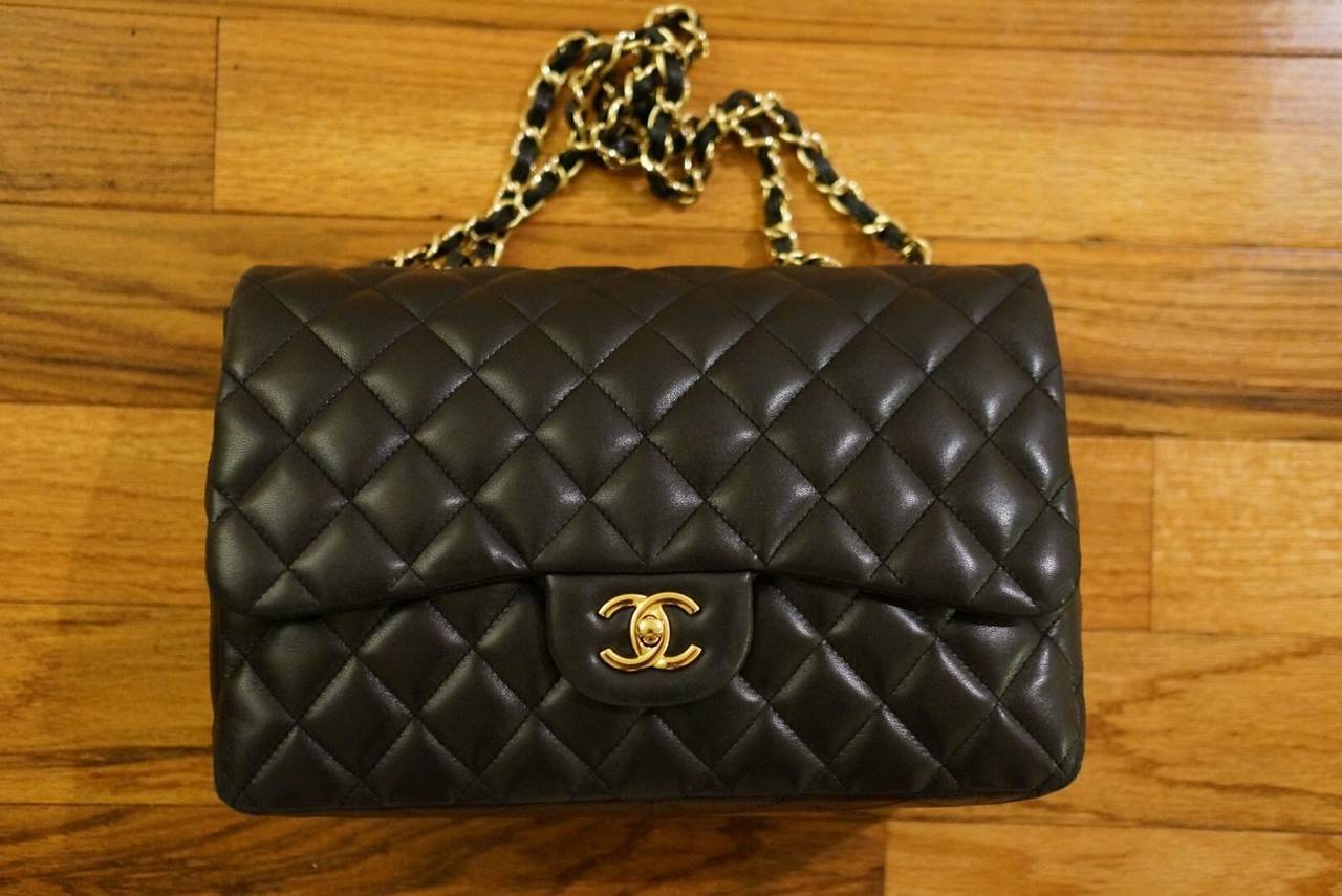 This is an authentic CHANEL Lambskin Jumbo Single Flap in Black Lambskin. This stylish shoulder bag is crafted of diamond quilted luxurious lambskin leather. The bag features gold chain link shoulder straps threaded with leather and a gold frontal