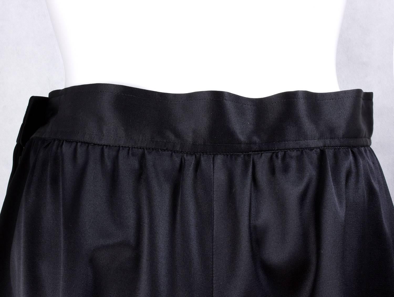Saint Laurent black large silk satin skirt featuring a fitted waistband, two side pockets, side button and zip opening, 1980 circa

Brand: Yves Saint Laurent

Size : 40 eu, 10-12 UK, 6-8 US

Material: silk satin

Condition: good condition, Some