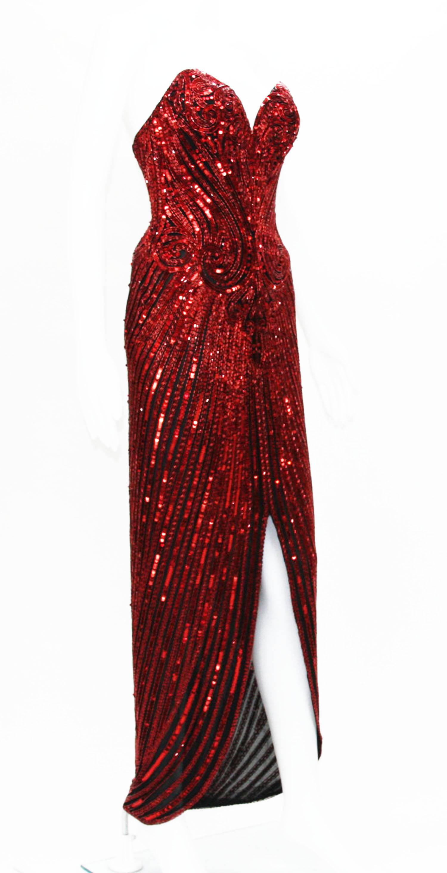 Une magnifique robe Bob Mackie de 1982.
Taille de créateur 6. 
Couleur - Rouge foncé.
Le filet noir est orné de perles et de paillettes.
Corset et ceinture. Entièrement doublé.
Mesures : Poitrine - 32 pouces, Taille - 26 pouces, Hanches - 34 pouces.