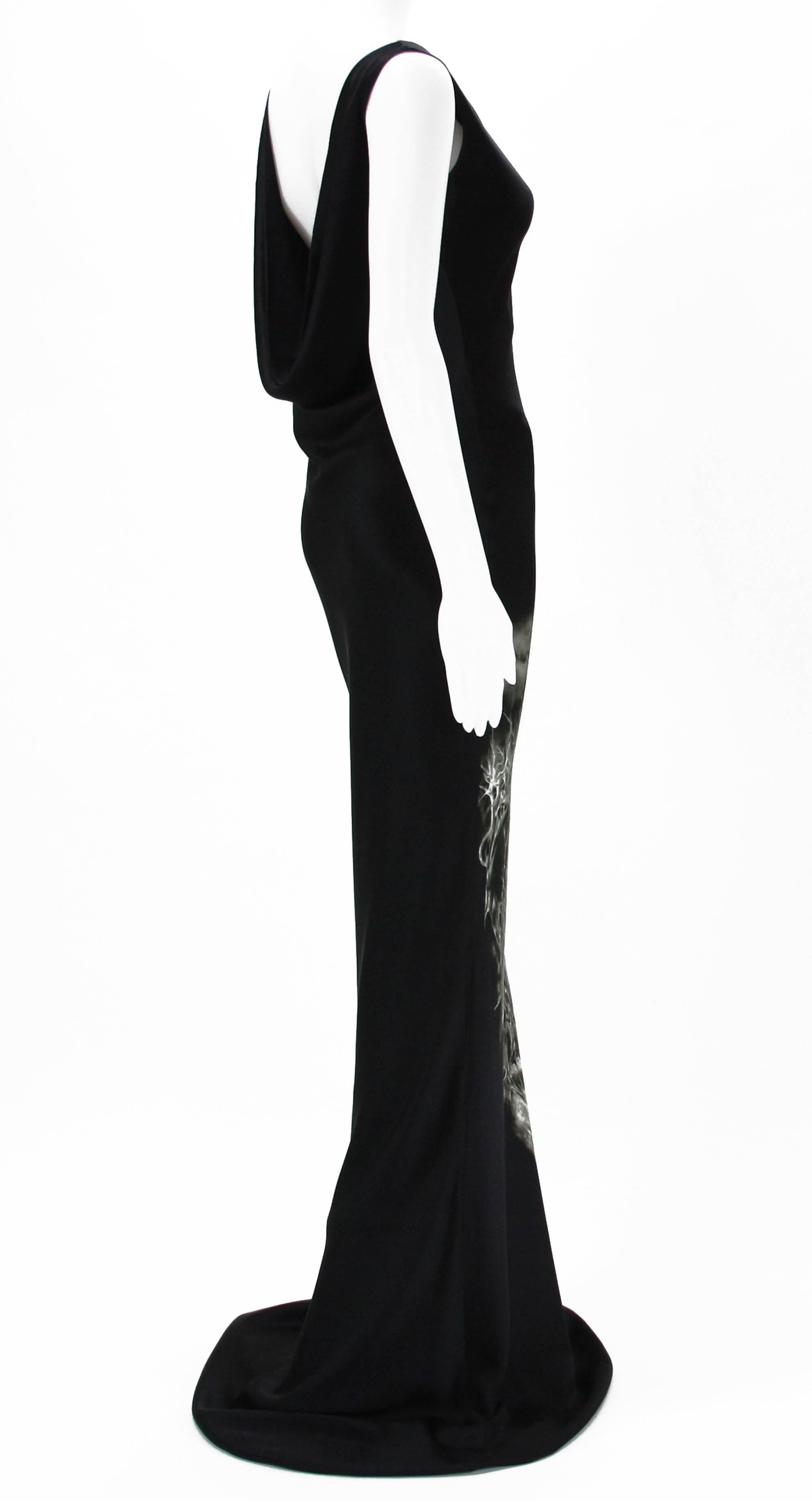 Alexander McQueen Black Silk Gown
2007 Collection
Designer Size - 40.
100% Silk.
Colors - Black and Gray, Print of Castle and Winged Skeletons.
Cowl Neckline, Sleeveless, Back Draped and Open to W, Trained Skirt, Fully Lined.
Made in Italy. 
New