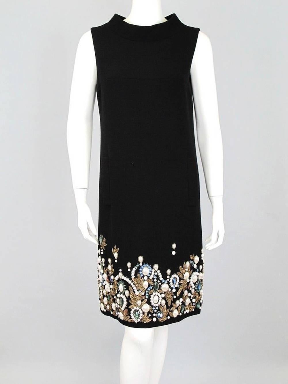 Oscar de la Renta Black Cocktail Dress
Designer Size - 6 
100% Wool - Heavy-weight, wool crepe fabric.
Intricate Gold Leaf, Pearl, and Gem Embroidery at hem.
Wide funnel neck, Sleeveless, Front Vertical Pockets, Back Zip Closure, Silk