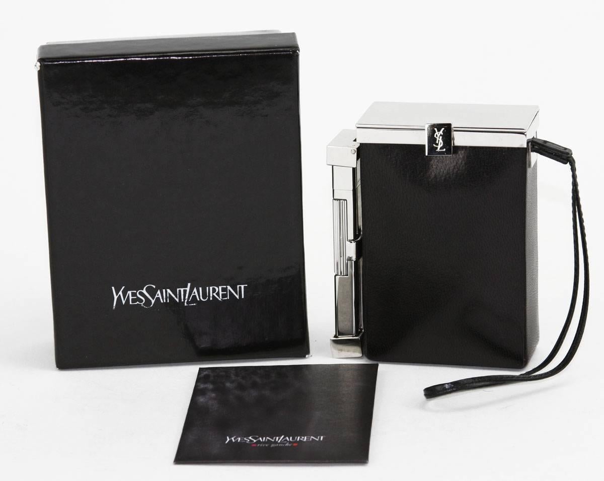 Tom Ford for Yves Saint Laurent
Spring/Summer 2001 Collection
An Yves Saint Laurent leather cigarette case and lighter. This item features a chrome tone latched hinged top that opens to a space suitable for a pack of cigarettes. Another latched