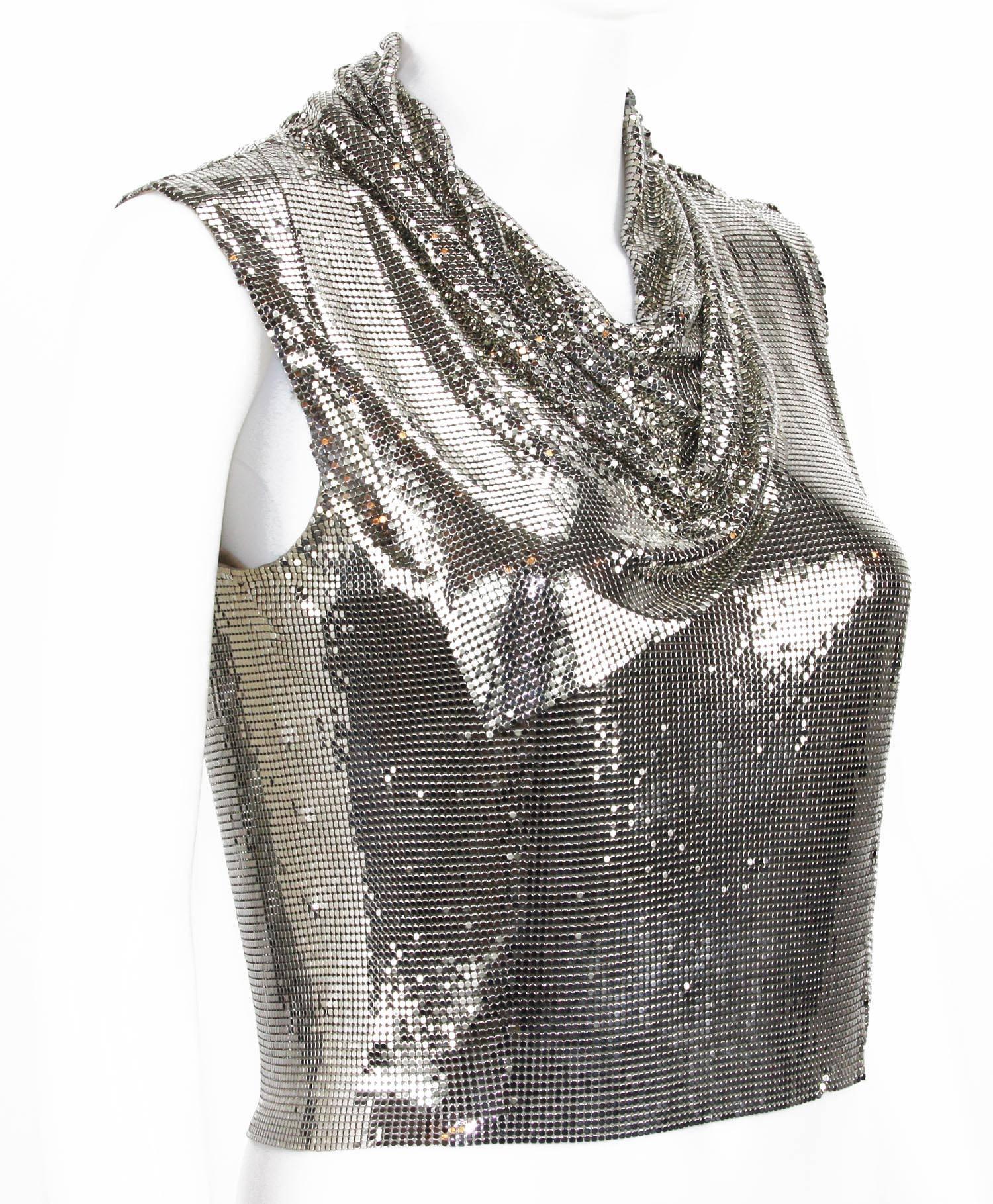 Gianni Versace Couture Icone des années 90 Maille métallique
Taille italienne 38
Maille métallique argentée
Ce haut est assorti d'une écharpe drapée en métal qui est attachée en permanence autour de la ligne de cou et qui a un aspect spécial et un