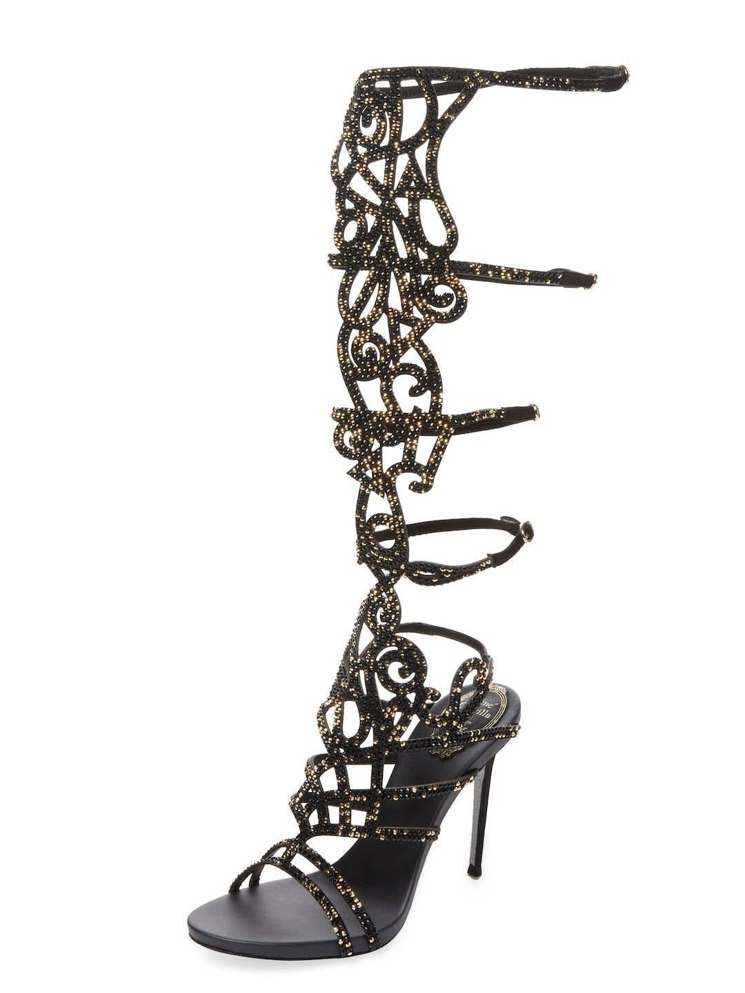 Rene Caovilla Knee-High Gladiator Sandals.
Designer size 36 - US 6
Leather upper with Swarovski crystals - black and gold.
4 inches heel, Leather Lining, Gold Tone Buckles.
15 inches H shaft with Buckled Straps.
Signature Glittered Sole.
Made in