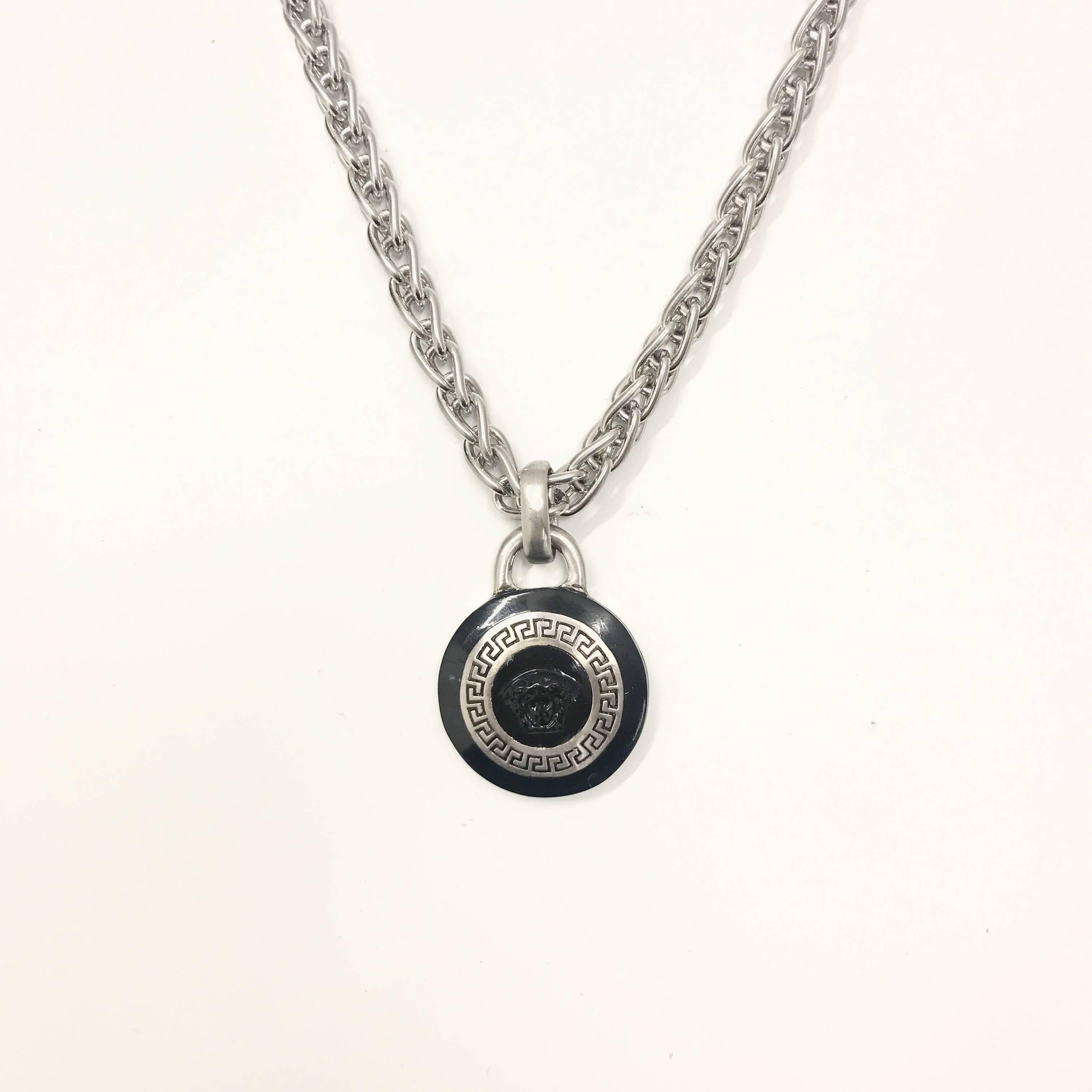 A staple of classic Versace design, this medallion contains both emblematic motifs of the medusa head and a brushed silver mosaic on a black enamel base, keeping this item simple yet effective. The multi faceted link chain adds great definition and
