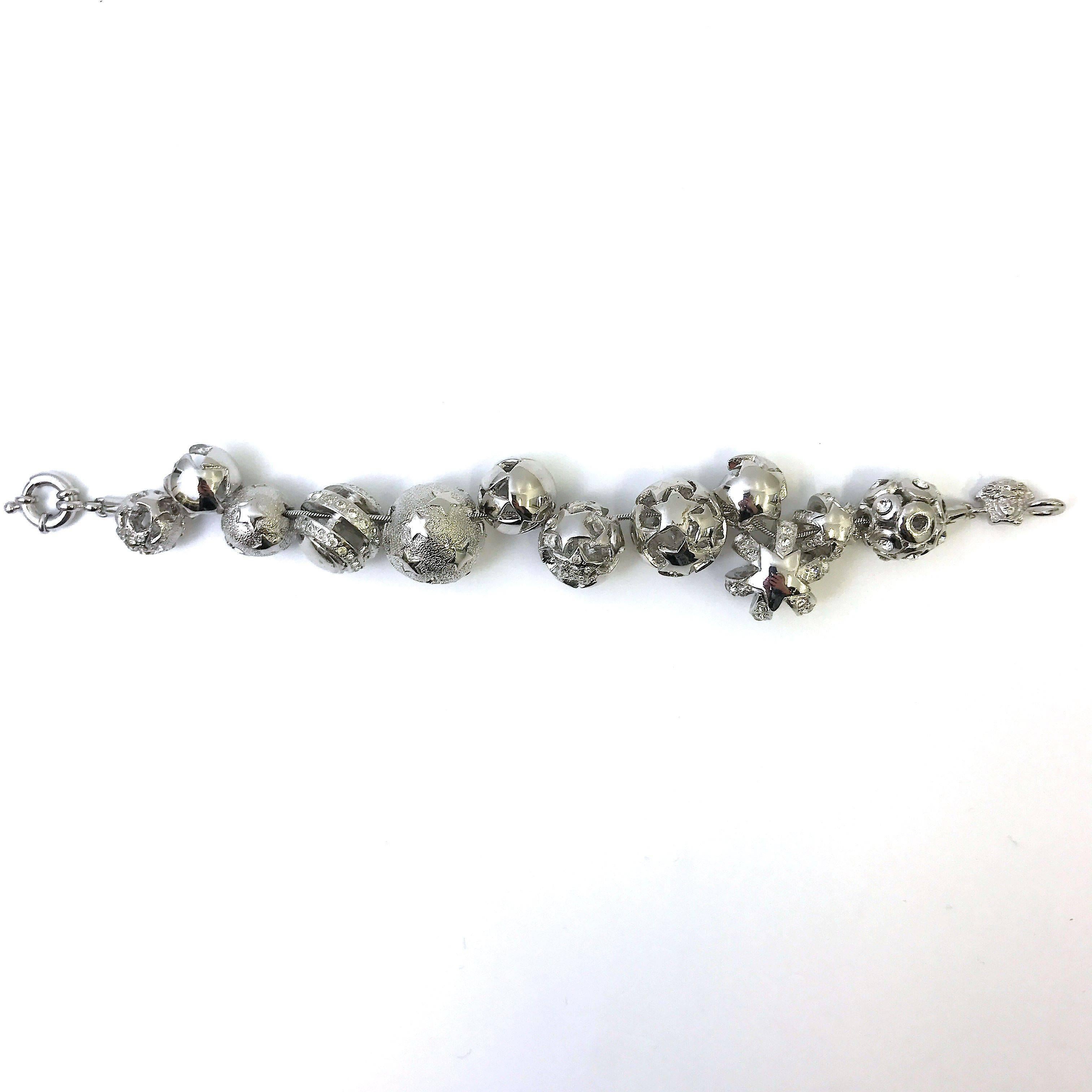 This bracelet by Gianni Versace is rare with it's unique detailing of balls with different cut-out patterns. The silver tone complements beautifully against the sparkling stones. The balls are individually hand crafted and are unique to themselves