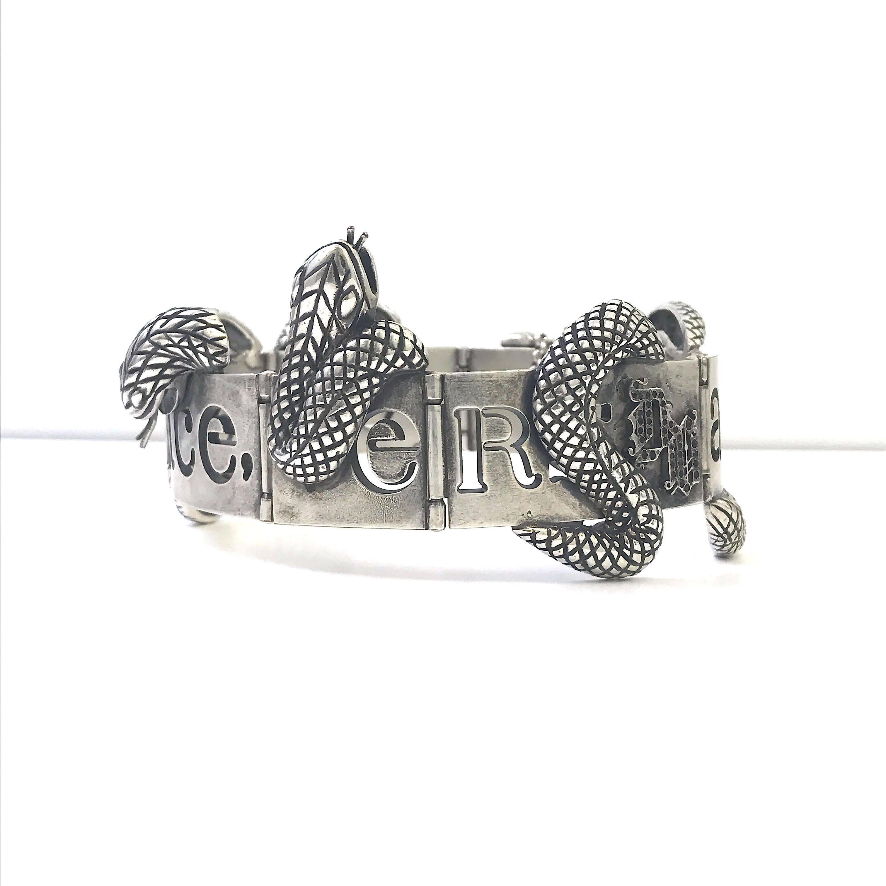 This Gianni Versace snake choker is a masterpiece. Part of the designers gothic movement the item is beautifully hand-crafted from a distressed silver tone metal. The main statement of this spectacular piece are the two metal snakes intwined around