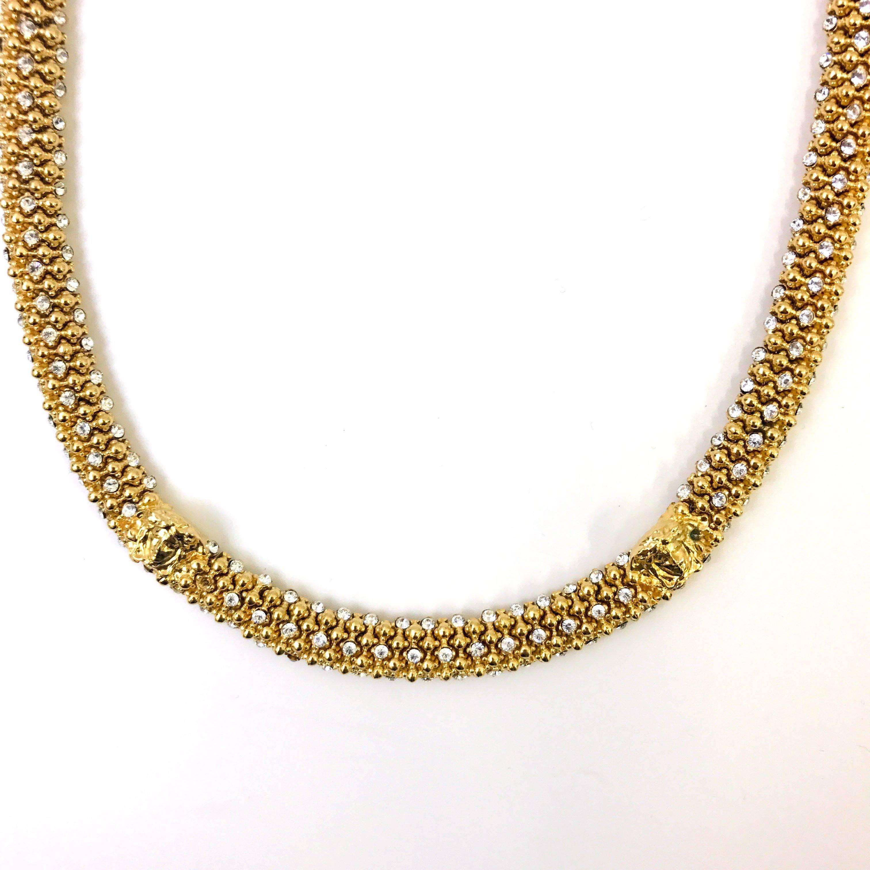 This Gianni Versace necklace has a matinee style which falls perfectly on your chest making it a statement piece on any outfit. The necklace features a omega ball style chain with diamantes placed throughout the piece which sparkles under any light.