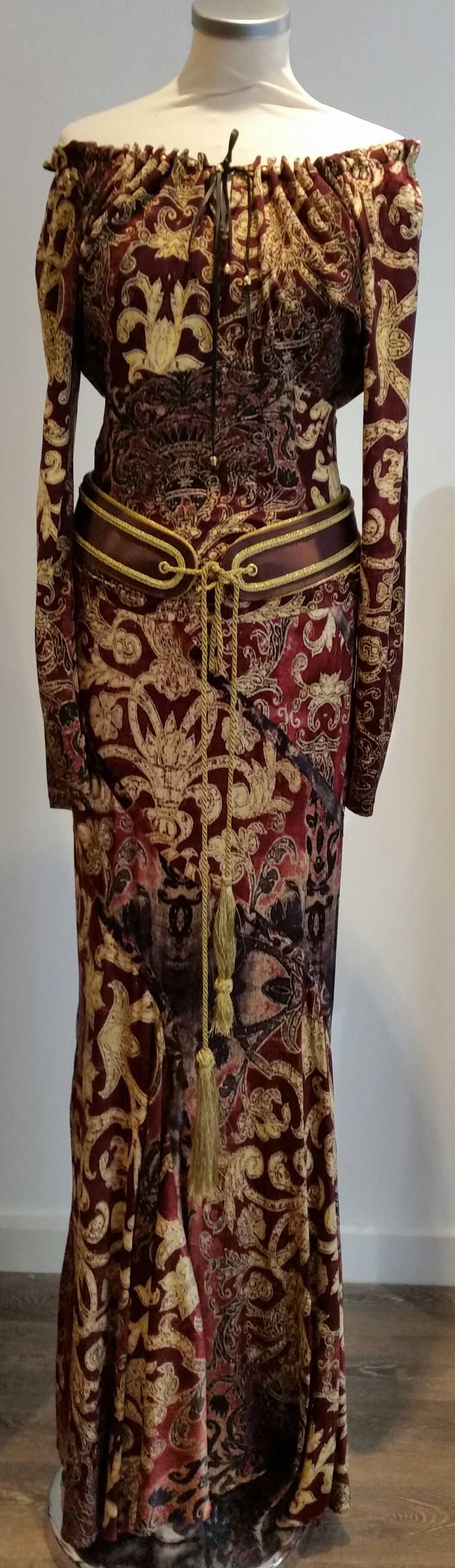 This Robert Cavalli outfit is a stunning piece. Rich burgundy and antique golds.
It is actually a two piece. Peasant style top can be worn on or off the shoulder with a leather tie. It is a size Sml
It is a stretchy silk.
The skirt is fitted with an