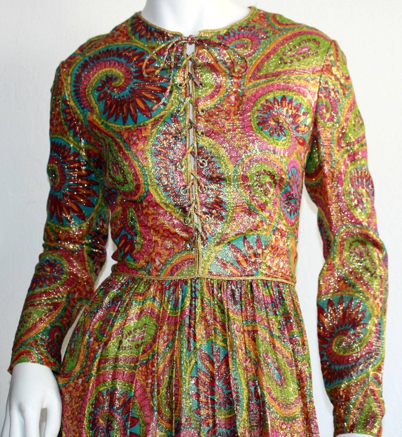 One of my favorite Mollie Parnis pieces ever! Chic paisley print throughout in vibrant colors (This metallic silk fabric is magnificent!) Features a tie up the bodice, with tiny rhinestones encrusted at each opening. A true gem! Fully lined. In