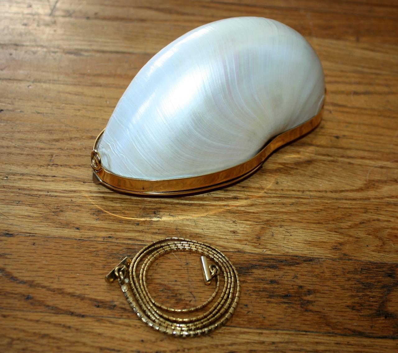 Extremely rare vintage Judith Leiber seashell minaudière, with detachable gold chain! This unique treasure originates from an actual seashell, complete with gold leather lining, and original duster. Leiber's seashell collection was only produced for