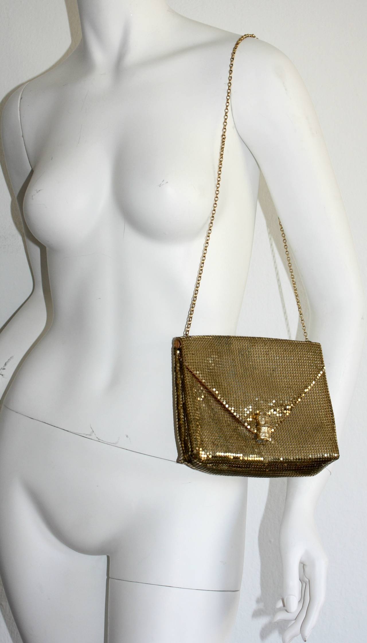 Beautiful shiny vintage Whiting and Davis gold metal mesh purse. Features an intricate clasp, with an attached chain (may be tucked in to use as a clutch). Can also double layer the chain for a shorter strap. In great condition