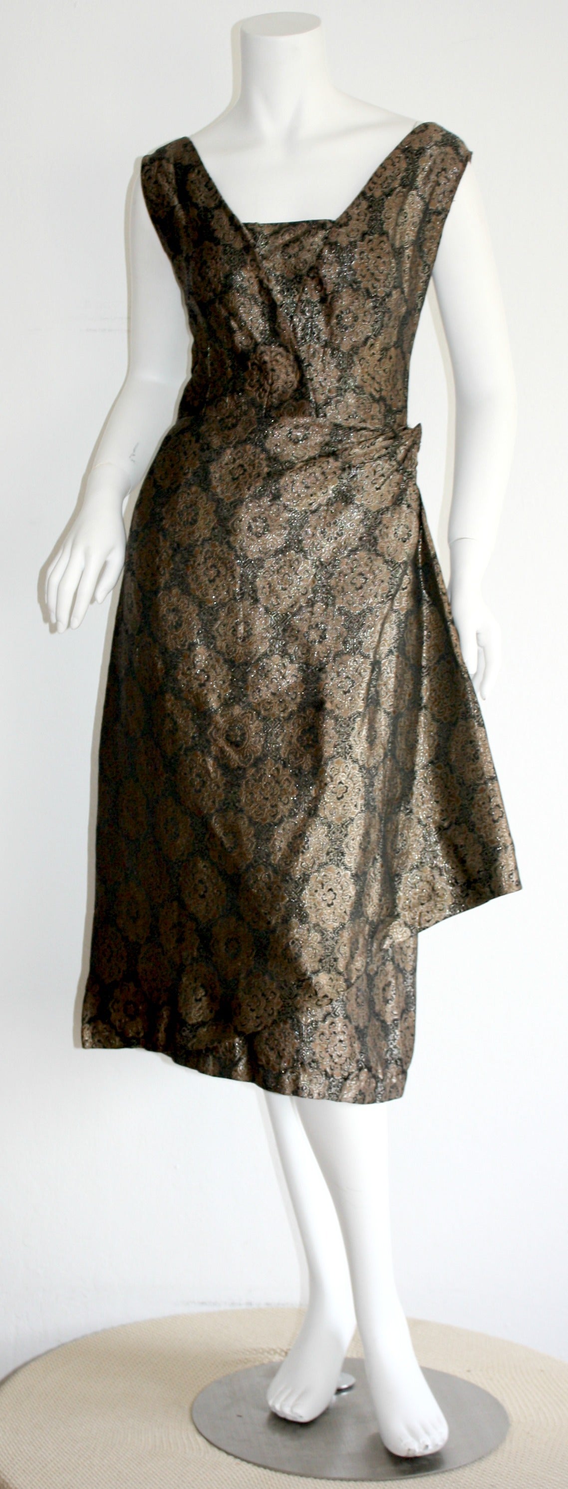 Extraordinary RARE vintage Nina Ricci wrap dress, with removable bust shelf! Features beautiful brown and black silk fabric, adorned with an all-over medallion print. Wrap style, that has side snaps, along with several hook-and-eyes, and hidden