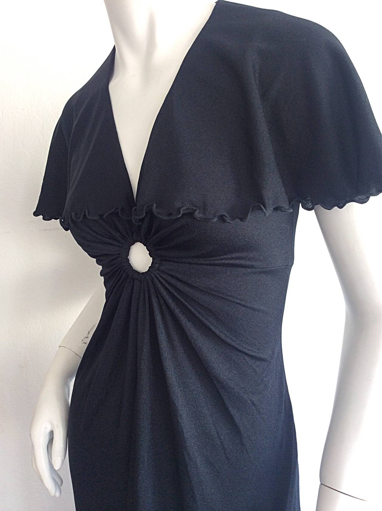 Stunning vintage Giorgio Sant Angelo black jersey keyhole dress! Features attached caplet, with lettuce edging at trim, and at hem. Sexy gathered bust, with keyhole detail. Can easily go from day to night. In great condition. Approximately Size