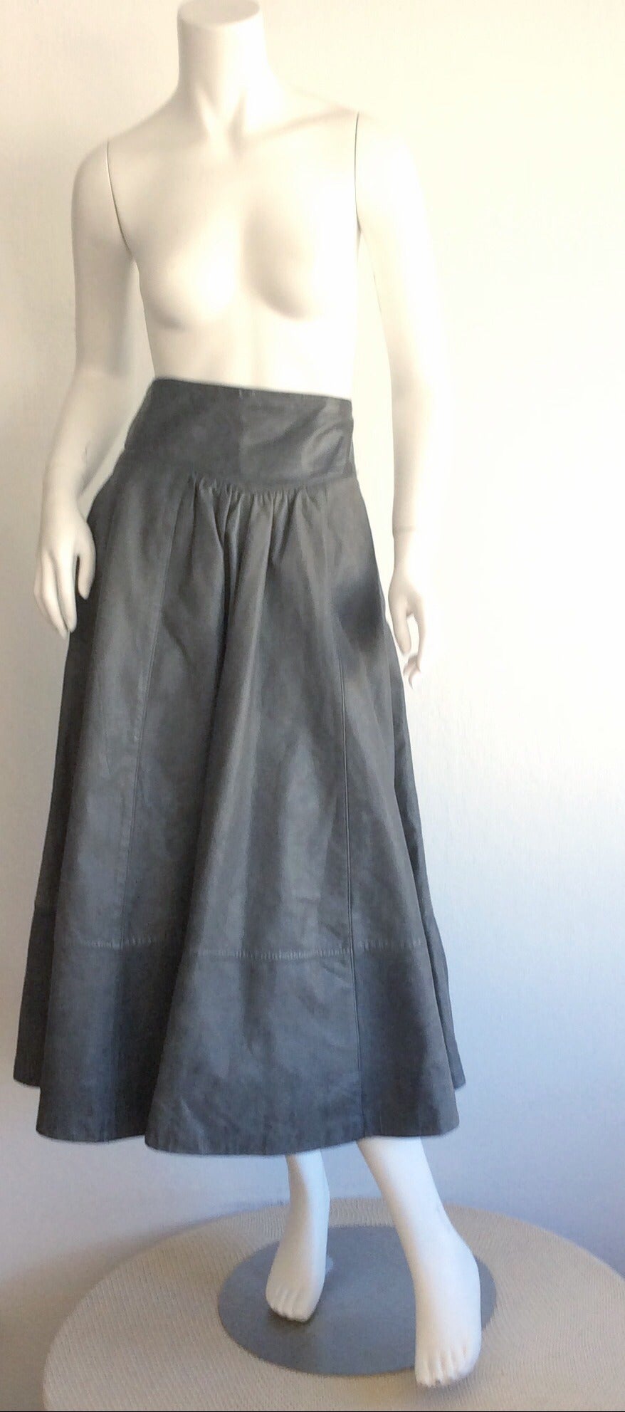 Outstanding vintage Guy Laroche elephant grey leather maxi skirt! Wonderfully constructed pleating detail, with intricate diamond shaped waistband. Features pockets at either side of the waist. Can easily go from day to night. Fully lined.