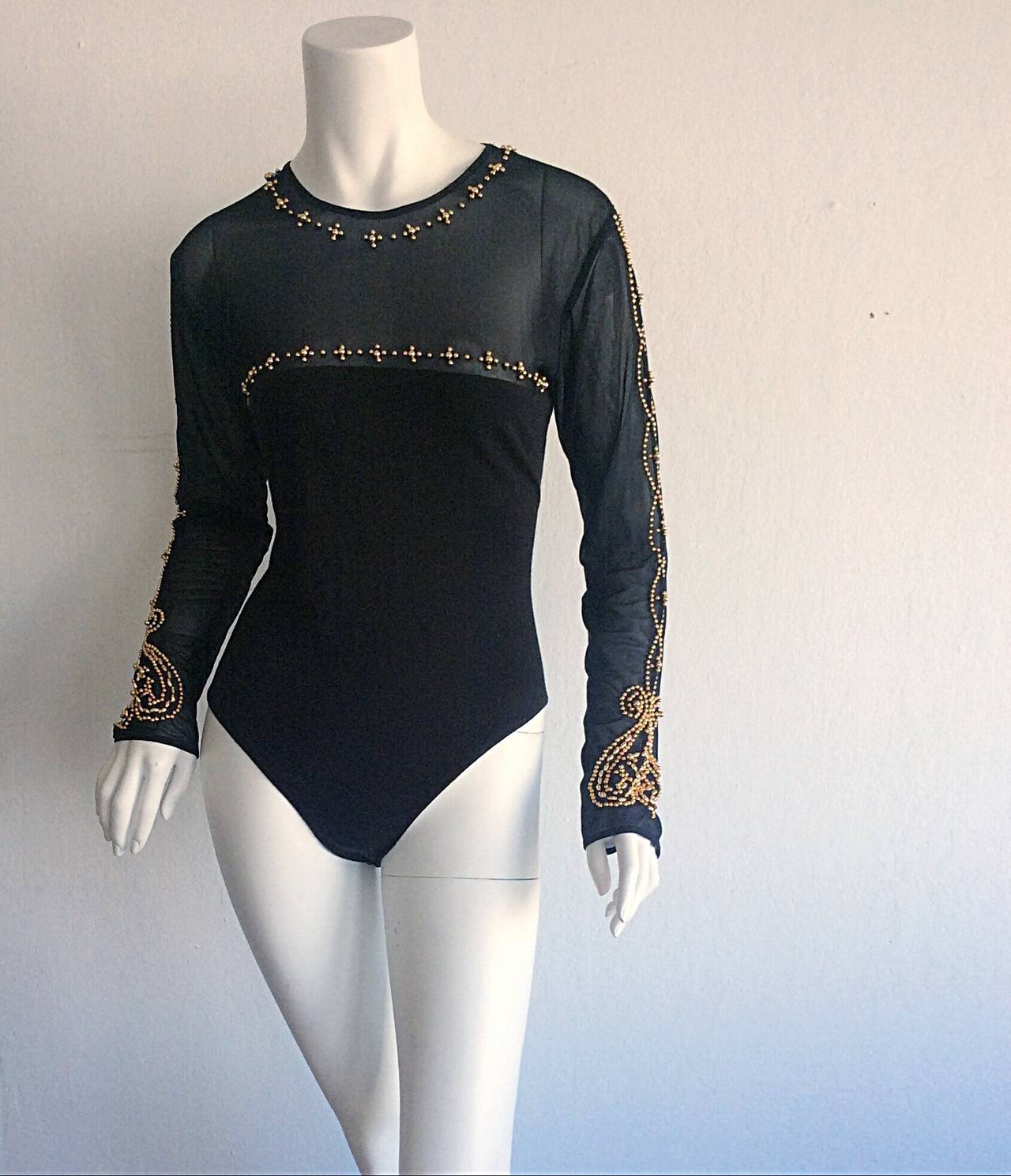 Sexy vintage Bob Mackie black cotton body suit, with a mesh bust and sleeves. Gorgeous gold beading throughout. Can easily be dressed up or down. Lovely with a ball skirt, yet perfect with jeans. In great condition. Approximately Size Small-Medium
