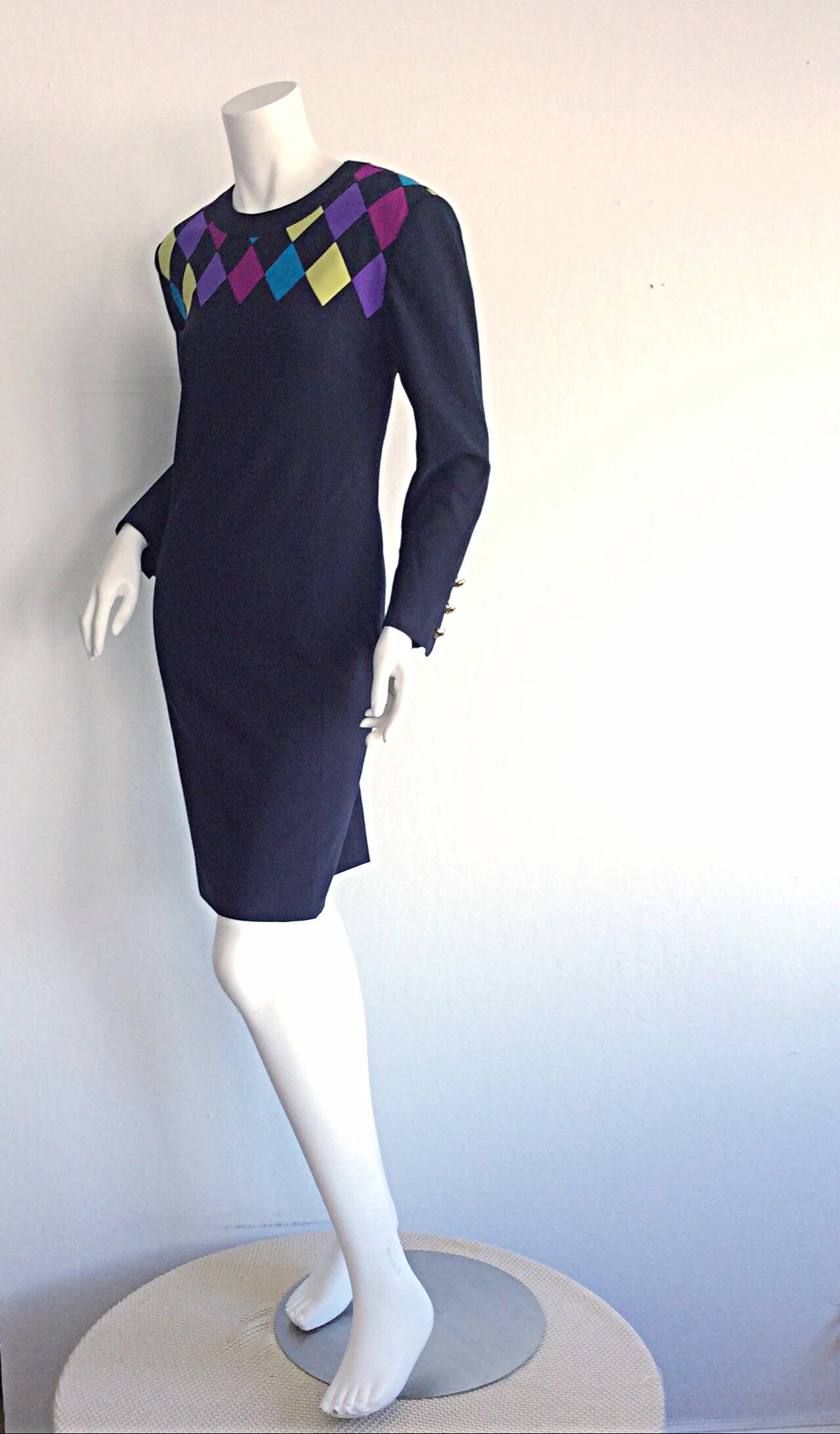 Extremely flattering vintage navy dress by Louis Feraud! Features colorful 'Harlequin' like print, with wonderful vibrant colors! Three mock metal buttons at each cuff. Looks great belted, or alone. Fully lined. In great condition
Made in West