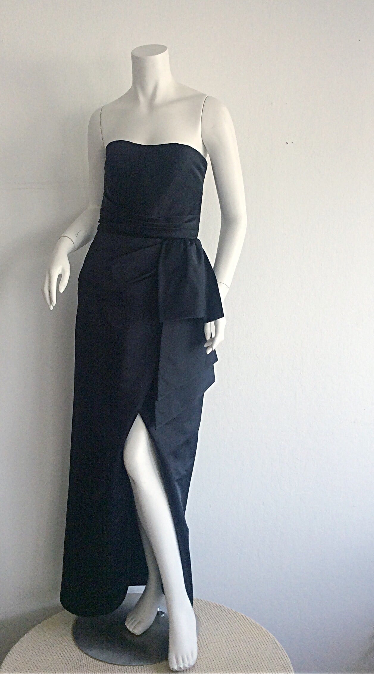 Beautiful strapless Victor Costa black silk satin gown! Origami/bow detail at waist, with a sexy slit at front hem. Extremely flattering fit, that is the perfect, classic black gown! Fully lined. In great condition. Approximately Size Small - Small