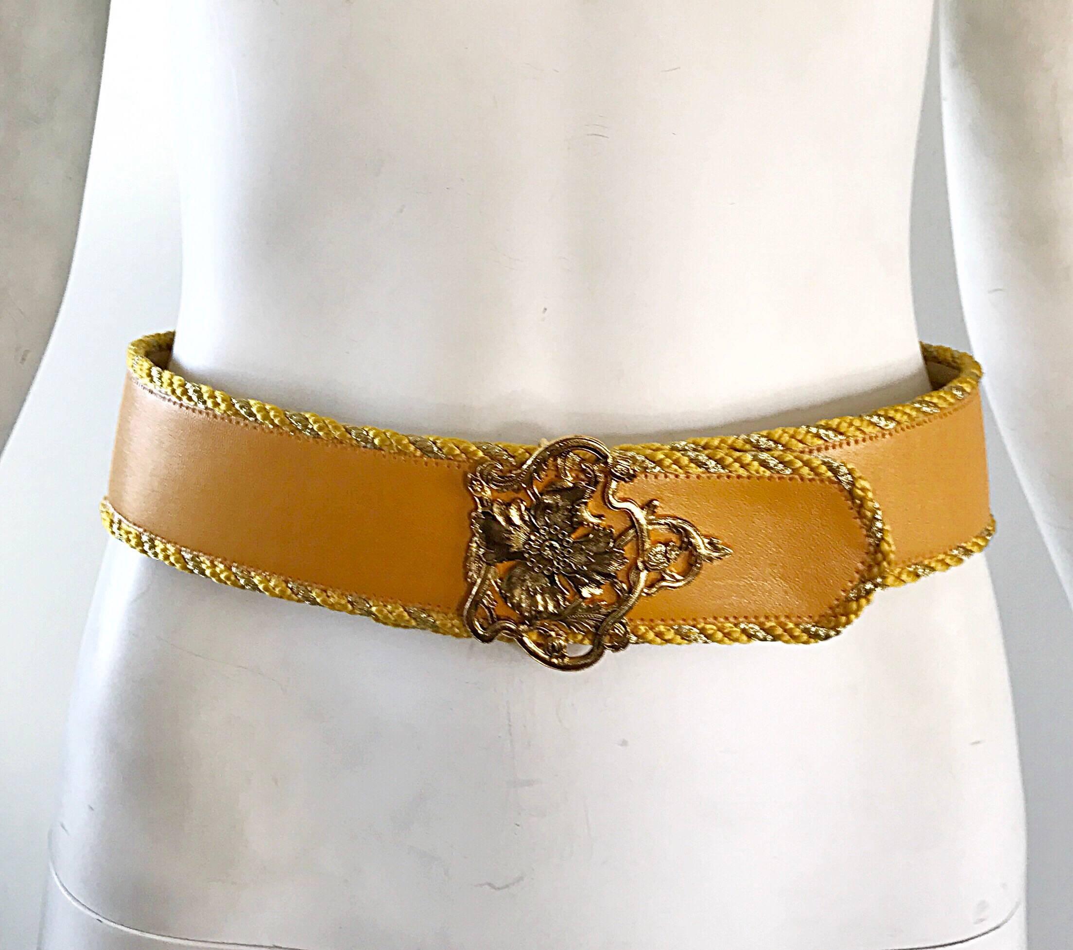 Beautiful 1990s EMANUEL UNGARO Marigold yellow and gold leather belt! Features a soft leather in a rich yellow color. Gold silk cording line the top and bottom of the belt. Gorgeous intricate gold flower buckle. The perfect accessory to add just the