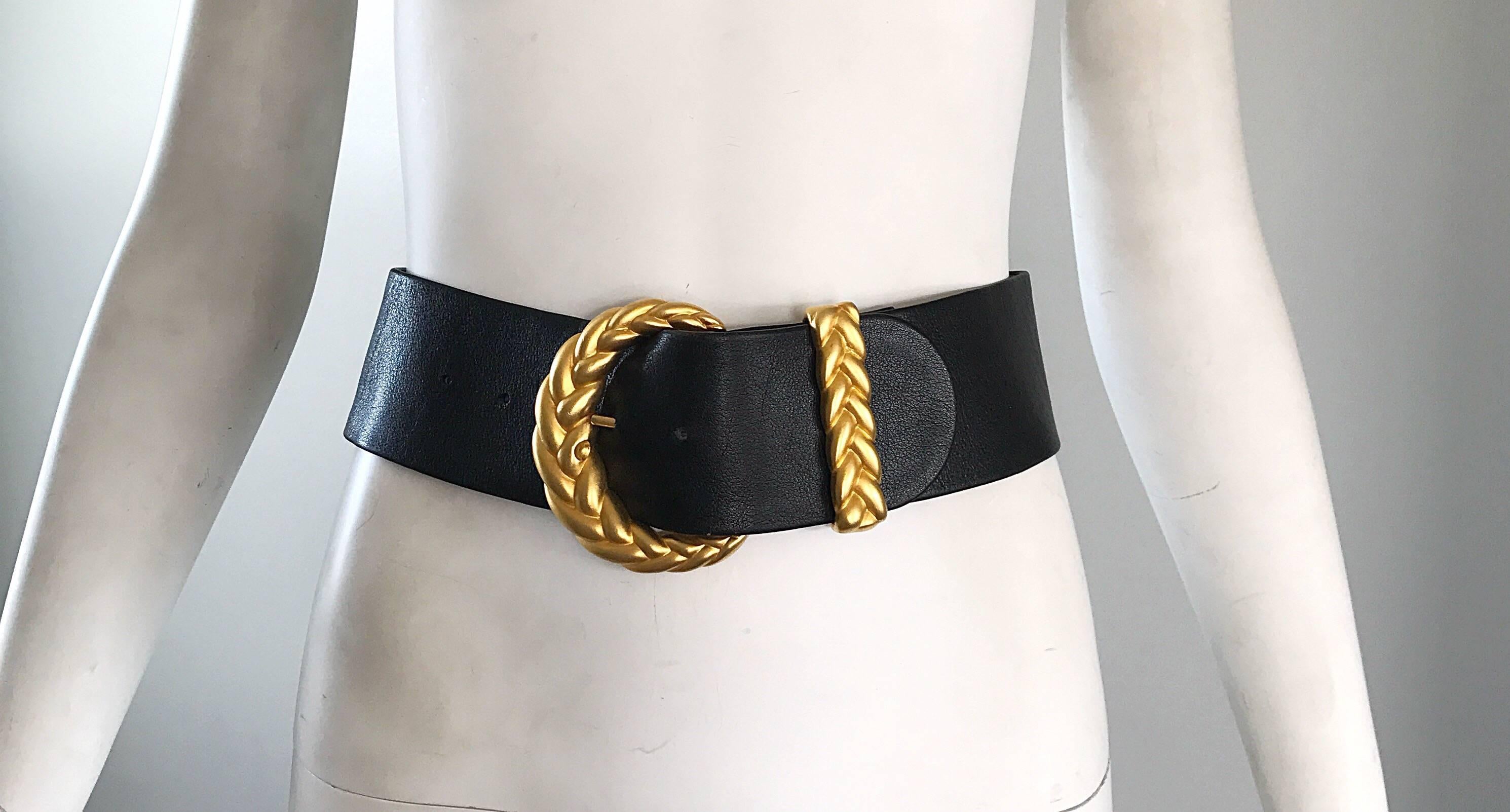 Brand new chic 1990s ANNE KLEIN for CALDERON black and gold wide leather belt! Features an oversized matte gold braided buckle and loop. Can easily be dressed up or down. Great with jeans, a skirt, or over a dress! In great unworn condition. Made in
