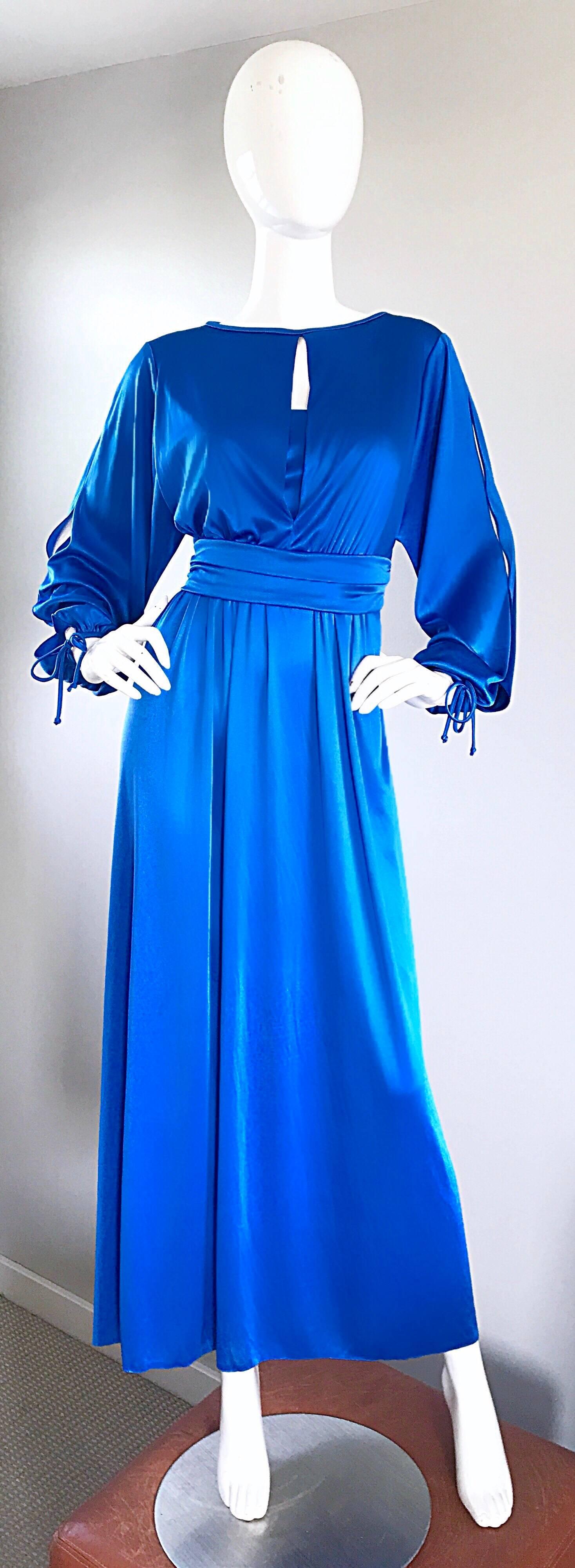Amazing 1970s HOUSE OF BIANCHI royal blue jersey disco gown! Features a fitted bodice, with a plunging neckline. Built in interior shelf at bust. Long bishop sleeves tie at each cuff, and have open slits up the arms and shoulders. Hidden zipper up