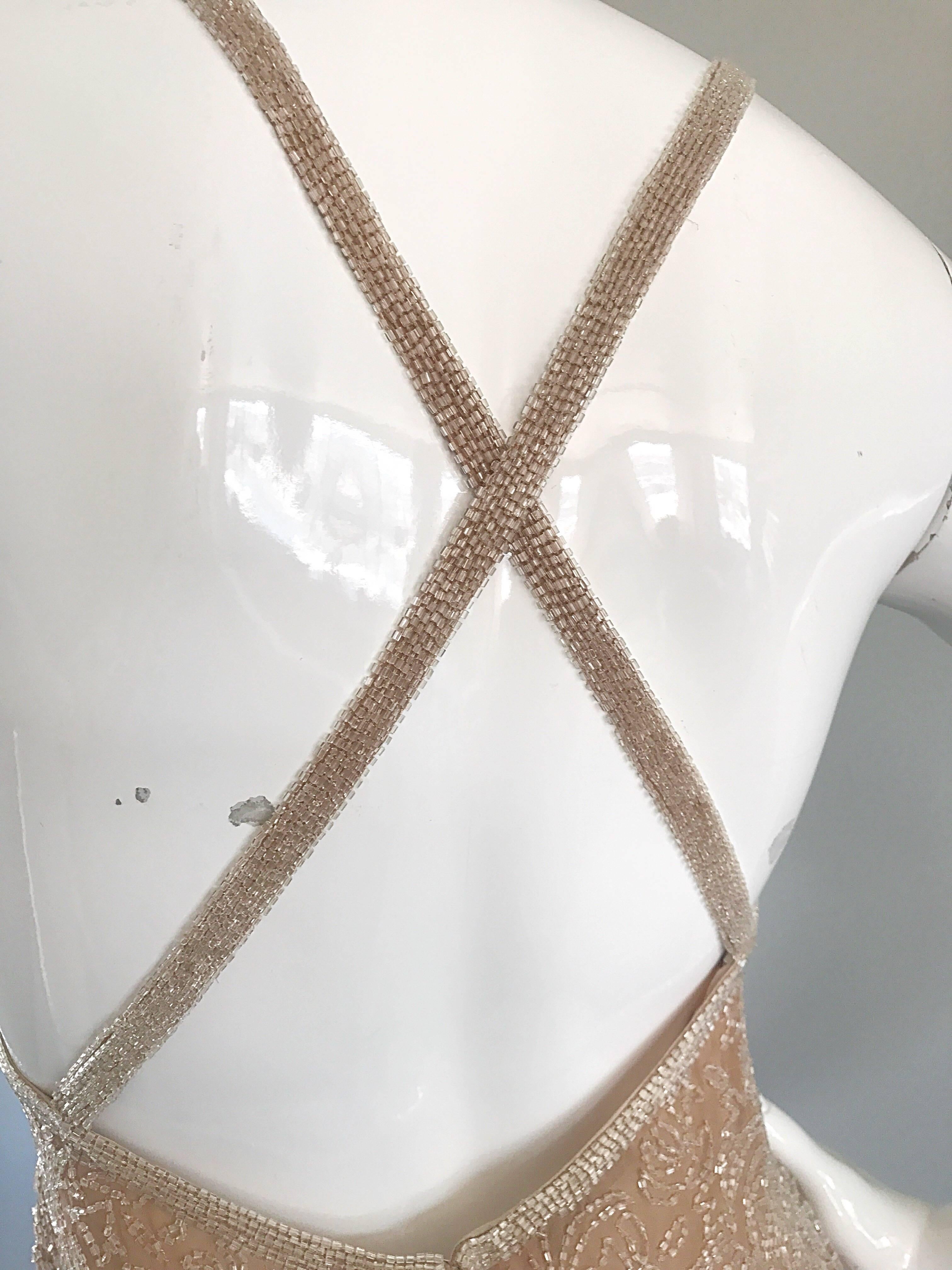 Gorgeous and flirty brand new (with tags) nude / tan heavily beaded babydoll dress! Features thousands of hand-sewn clear iridescent seed beads throughout. Flattering racerback 
criss-cross back. Fitted bodice with a flirty skirt. Hidden zipper up