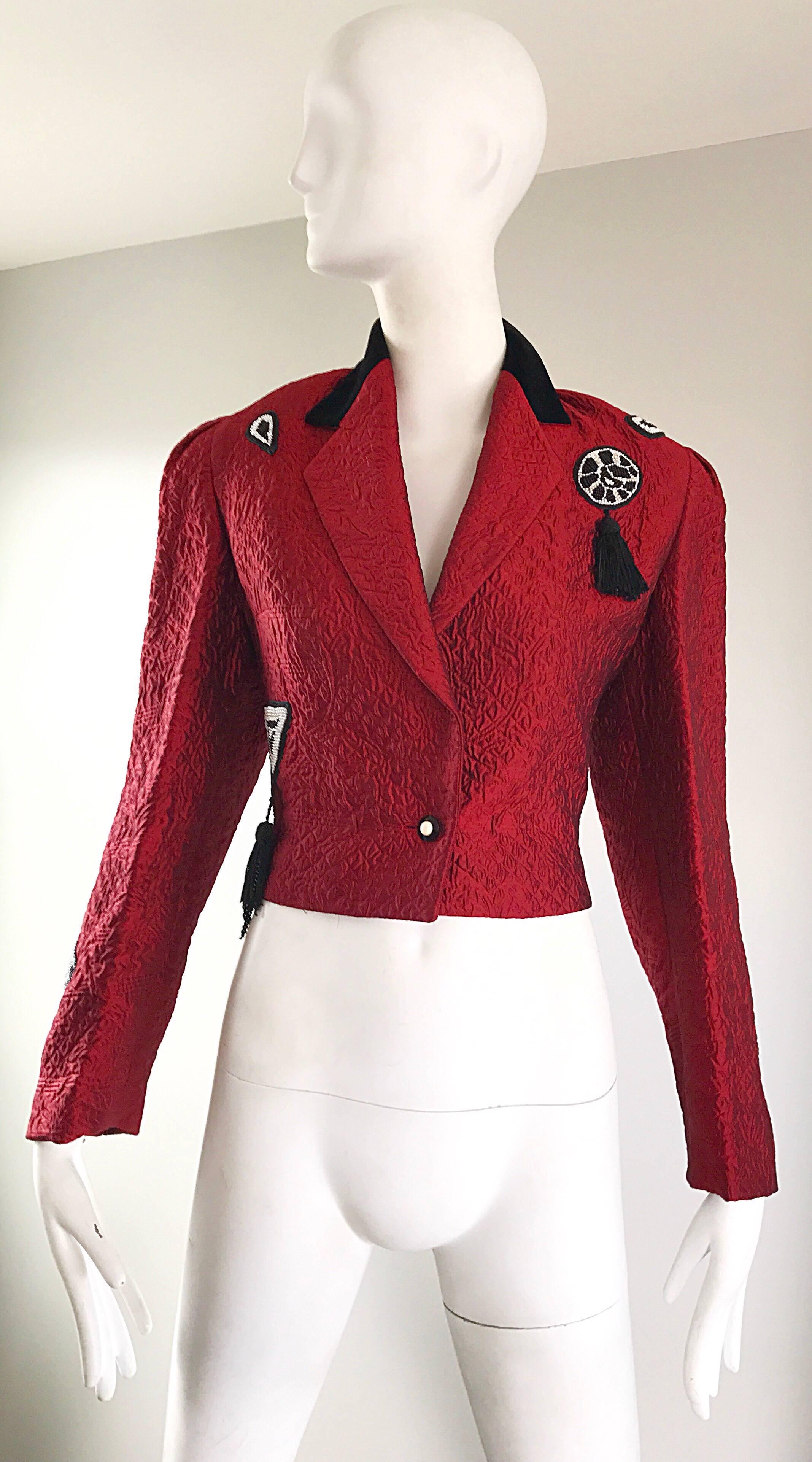 Chic vintage 90s LOUIS FERAUD crimson red, black and white Matador style cropped bolero blazer acket! Features a textured sturdy silk fabric, with a black velvet collar. Beaded detail at both the top left and right shoulders (black fringe tassel at