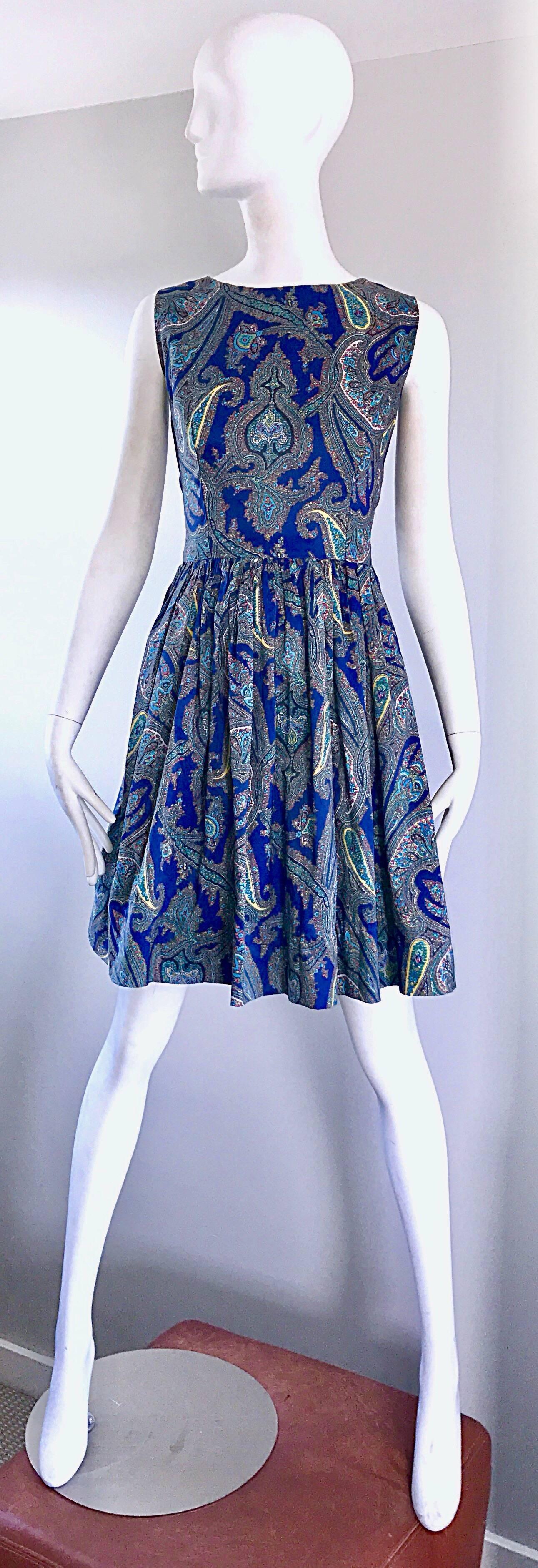 Beautiful 1950s blue paisley fit and flare sleeveless silk dress! Features a vibrant blue backdrop, with colorful paisley prints in pink, yellow, turquoise, teal, and green. Fitted bodice, with a flattering and forgiving full skirt that could also