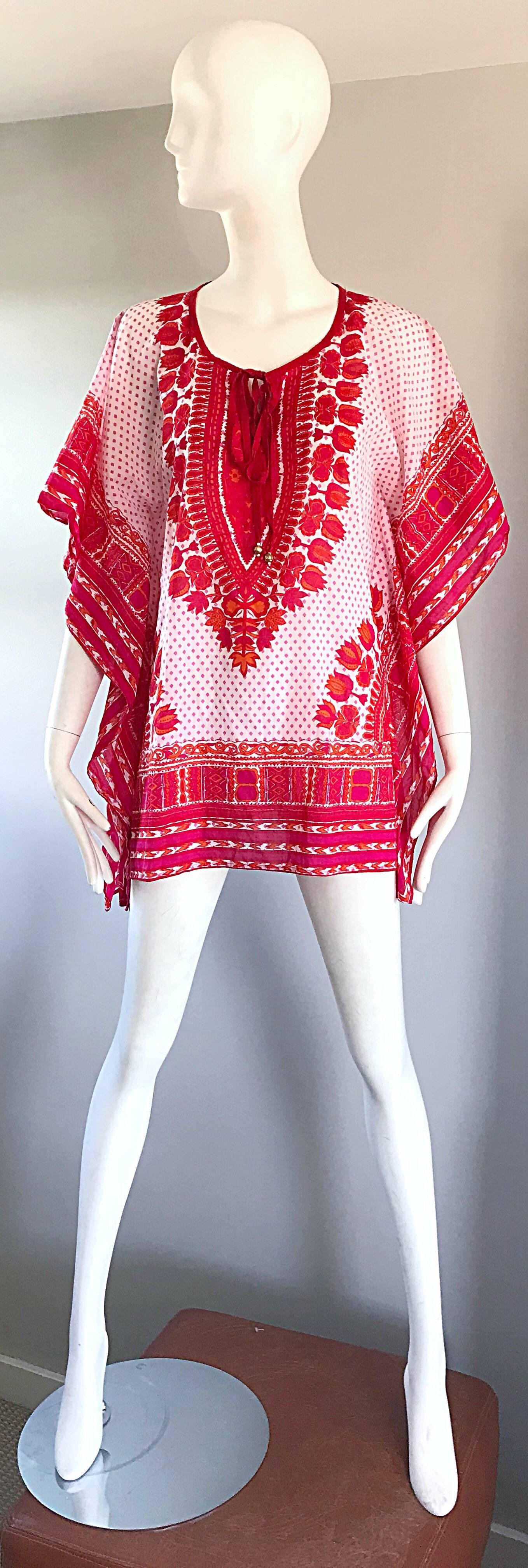 Superb 70s BIBA hot pink / fuchsia, orange, and red boho kaftan tunic blouse! Features an ethnic print in vibrant colors. Gold / brass beads at the end of each tie at neck. Dolman sleeves can fit an array of sizes. Soft lightweight cotton is light