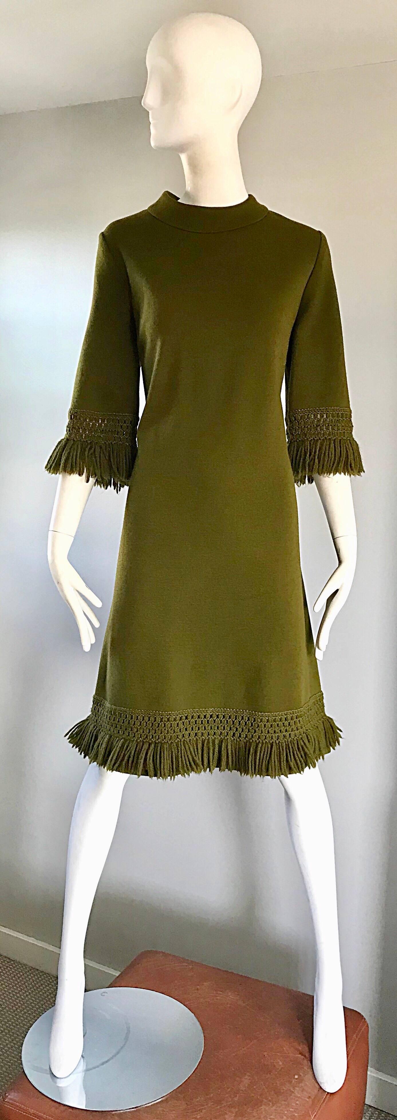 Stylish 1960s hunter green 3/4 sleeve virgin wool fringed A-Line dress! Features a fitted bodice, with a forgiving full skirt. Fringed sleeve cuffs and dress hem. Full metal zipper up the back with hook-and-eye closure. Great alone or belted, with