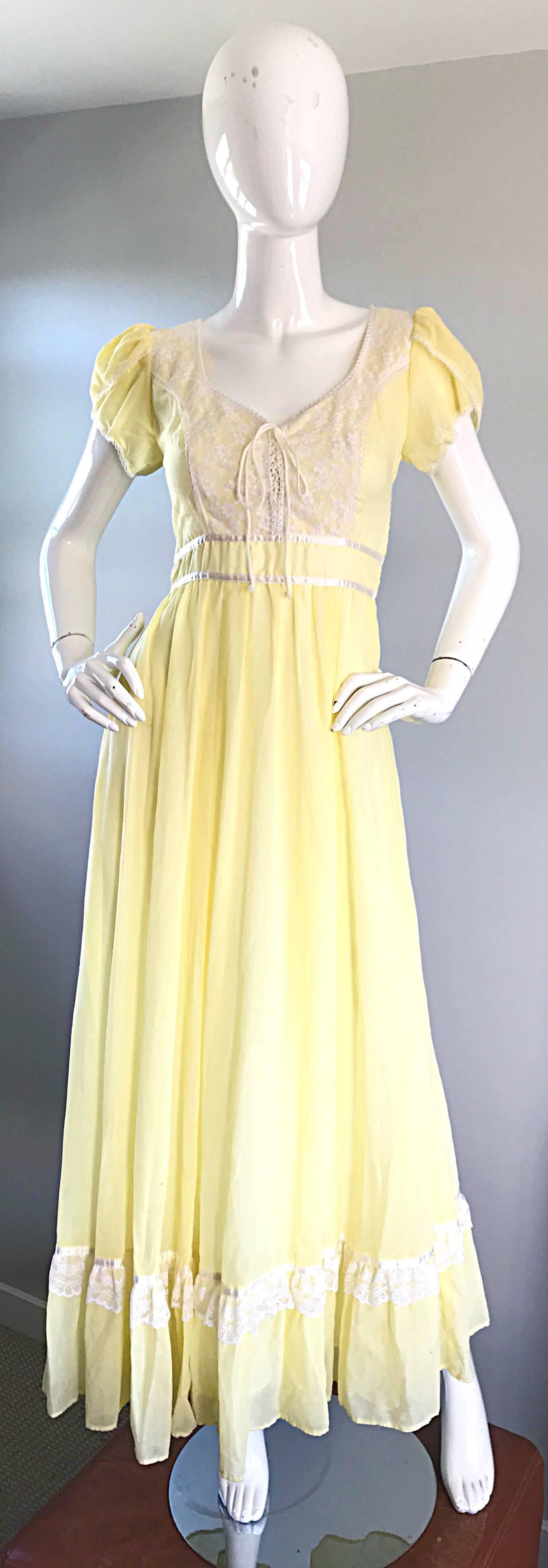 Beautiful 1970s pale yellow and white lightweight cotton voile boho maxi dress! Features a white lace bodice, encrusted with hand-sewn tiny pearls. Attached ribbon belt ties in the back. Ruffle hem also features a trim of white lace. Hidden zipper