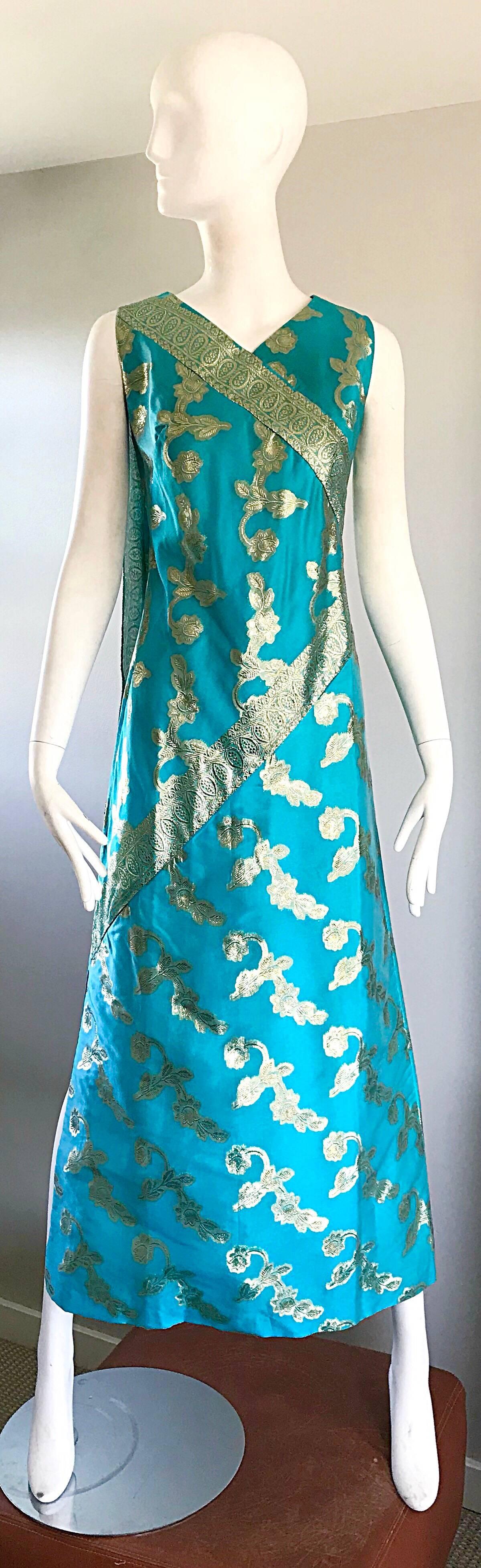 Amazing 1960s WALTAH CLARKE'S turquoise blue and gold metallic ethnic maxi dress! Features a fitted bodice, with an attached sash on top back right shoulder. Full metal zipper up the back with hook-and-eye closure. Fully lined. Perfect with sandals,
